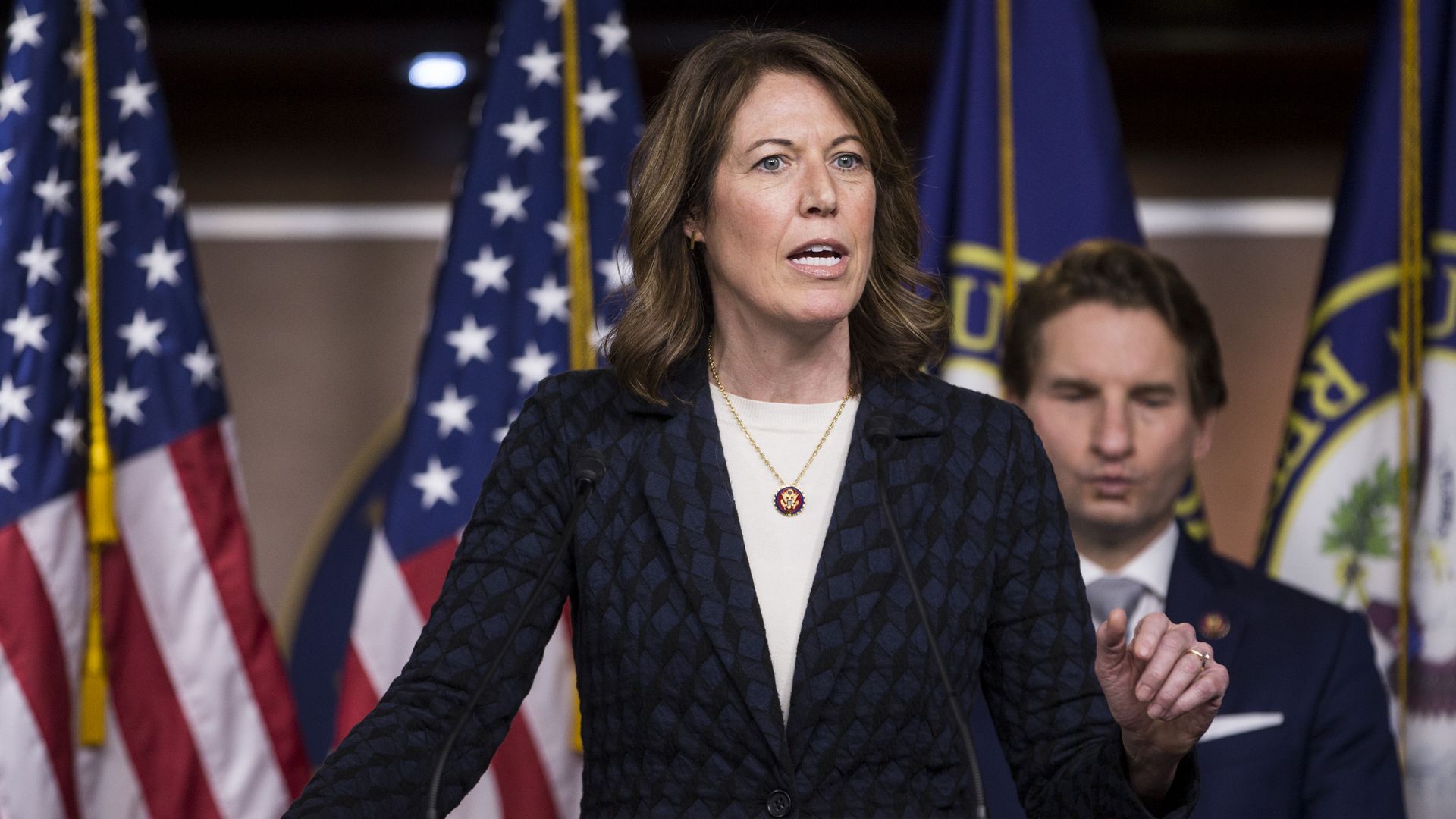 Rep. Cindy Axne of Iowa is seen speaking from a lectern.