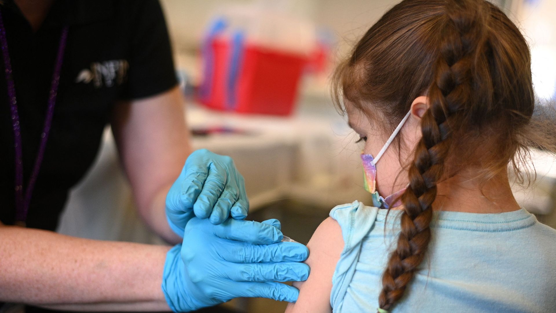 A nurse administers a pediatric dose of the Covid-19 vaccine to a girl at a L.A. Care Health Plan vaccination clinic