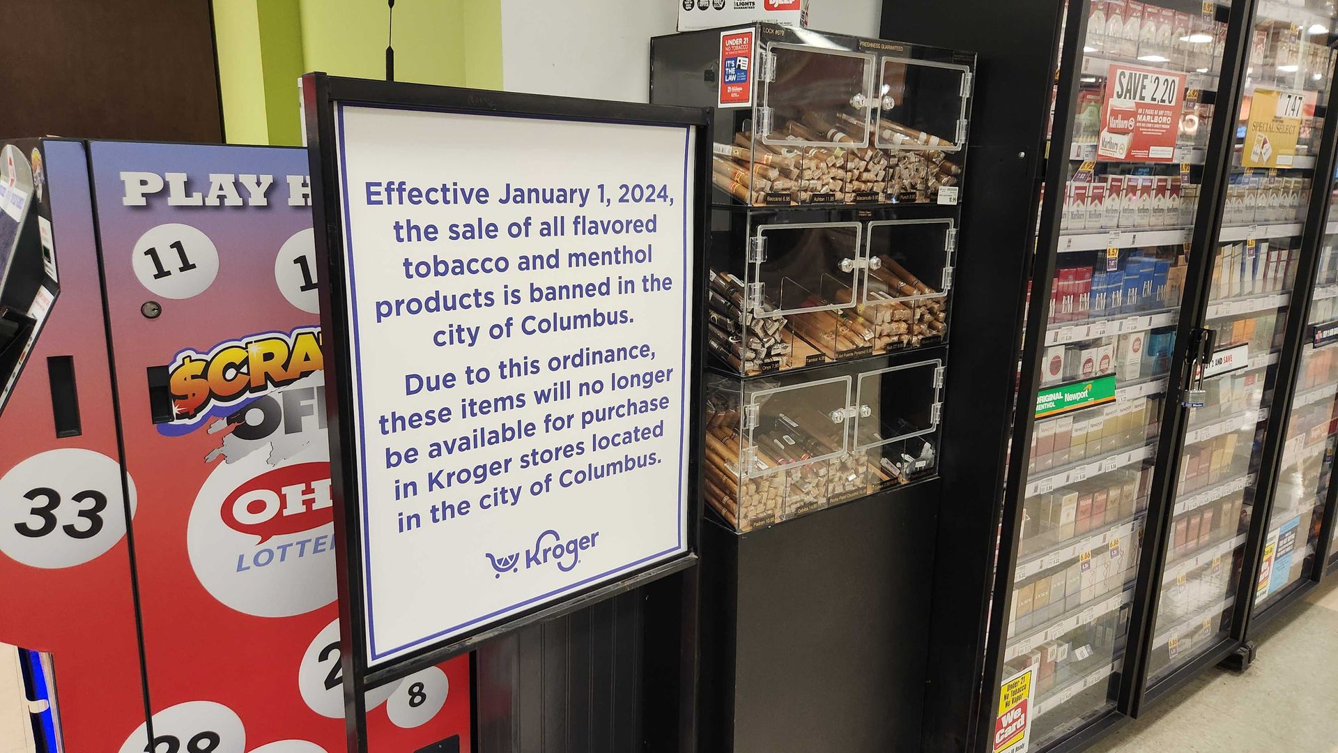 A sign next to a grocery store cigarette case tells shoppers about a flavored tobacco ban effective Jan. 1, 2024. 