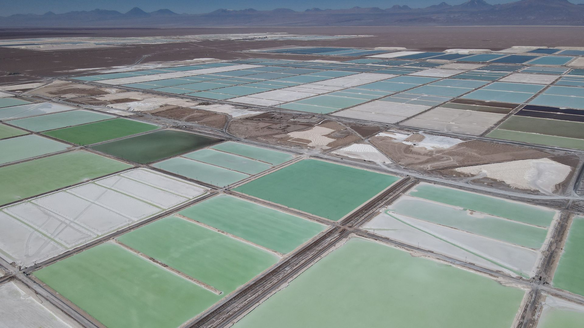 Pools of brine containing lithium carbonate and mounds of salt by-products stretch across a lithium mine in the Atacama Desert in Chile