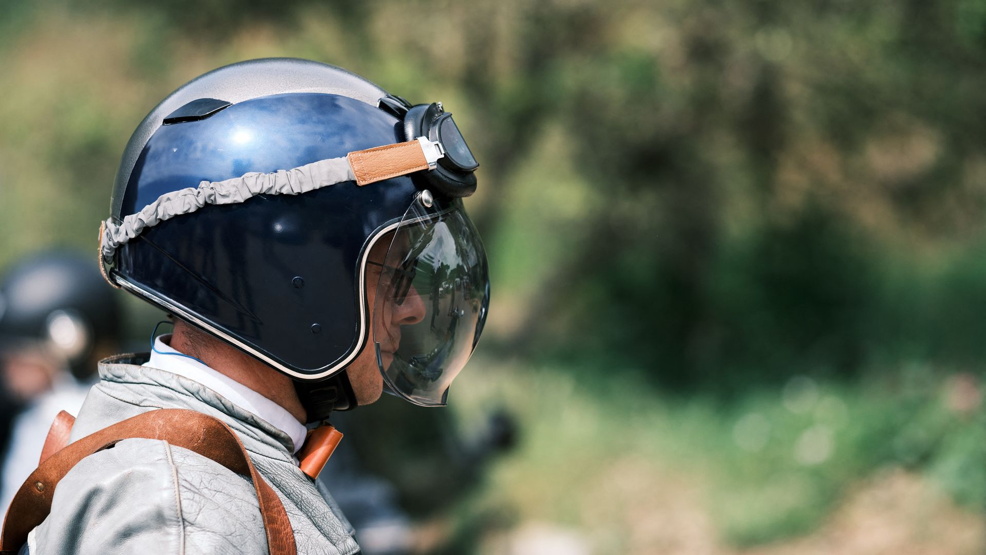 Portrait of a motorcyclist in profile with his retro helmet and round bubble, goggles on his head in Pornic, France on May 15, 2024. The Distinguished Gentleman s Ride "DGR" unites classic and vintage styled motorcycle riders from all over the world to raise funds and awareness for prostate cancer r
