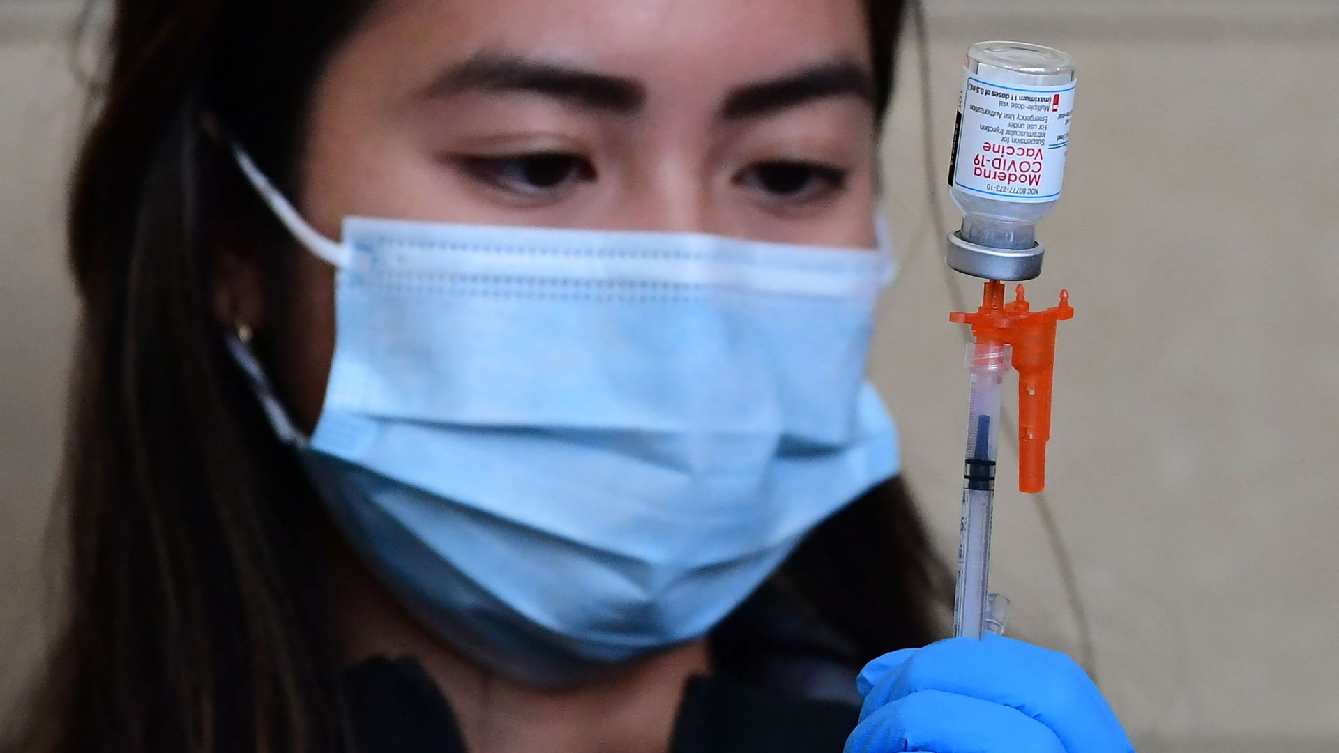 A health care worker preparing a dose of  Moderna's coronavirus vaccine.