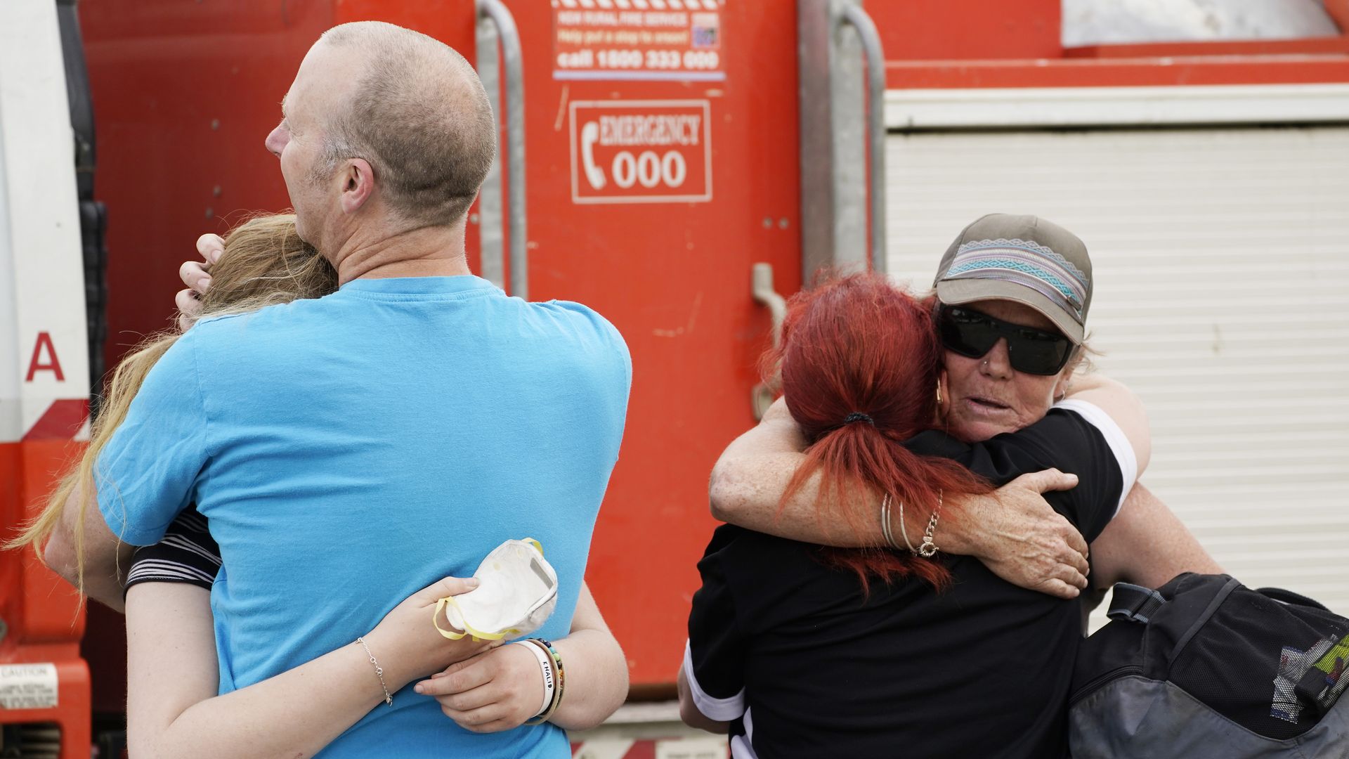 People are seen embracing at Numeralla Rural Fire Brigade near the scene of a water tanker plane crash in NSW