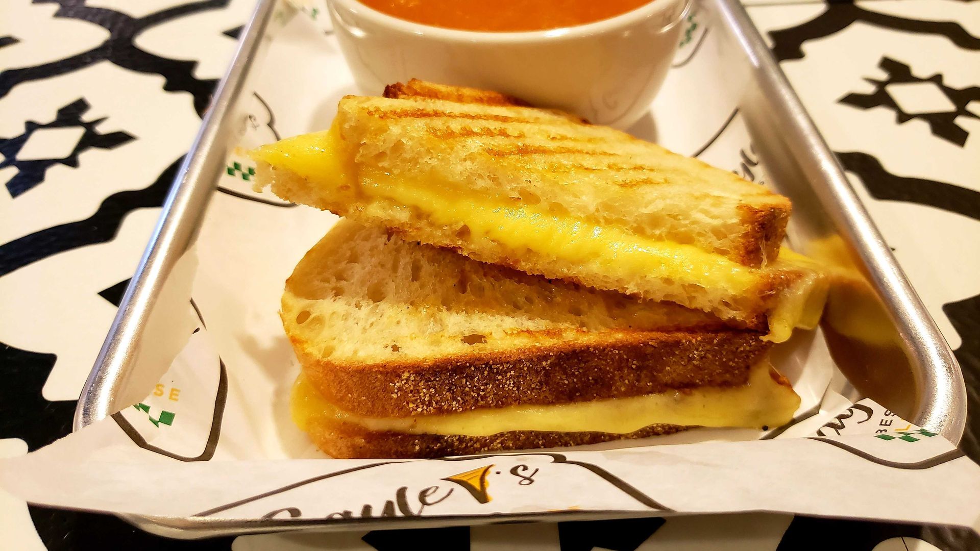 Photo of a grilled cheese sandwich with tomato soup. 