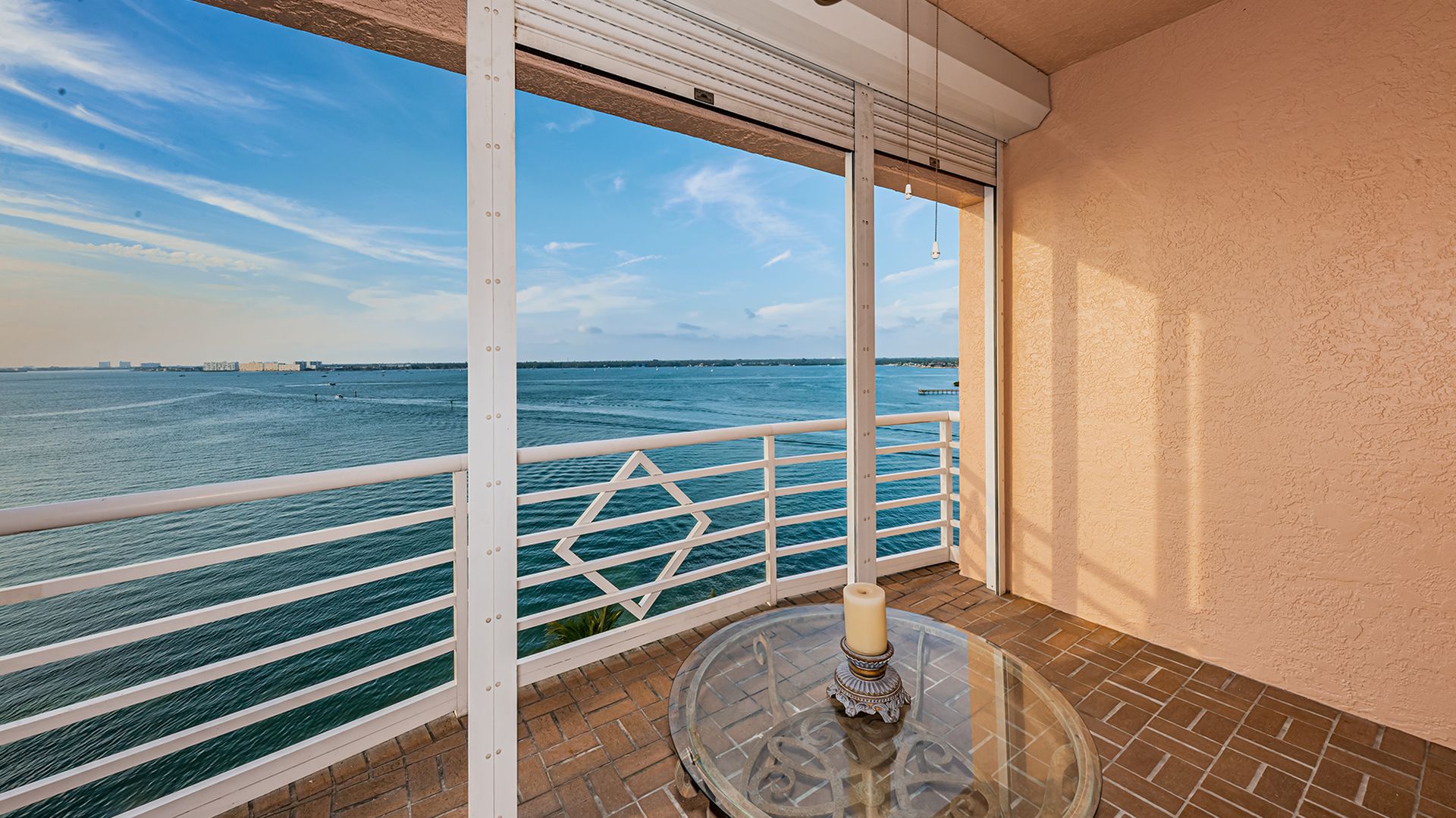 A brick-paved patio overlooking a vast expanse of blue water.