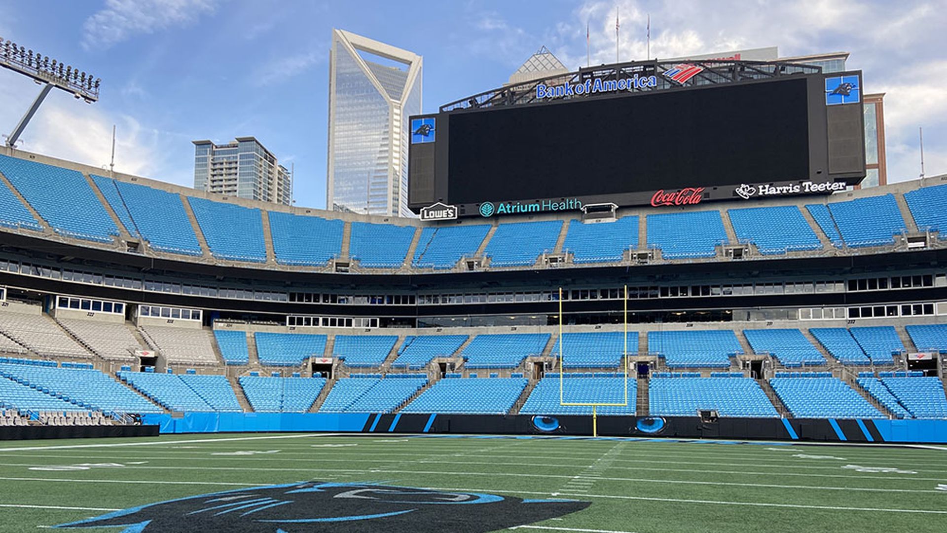 View of the Panthers logo on the field at Bank of America Stadium with the skyline in the background.