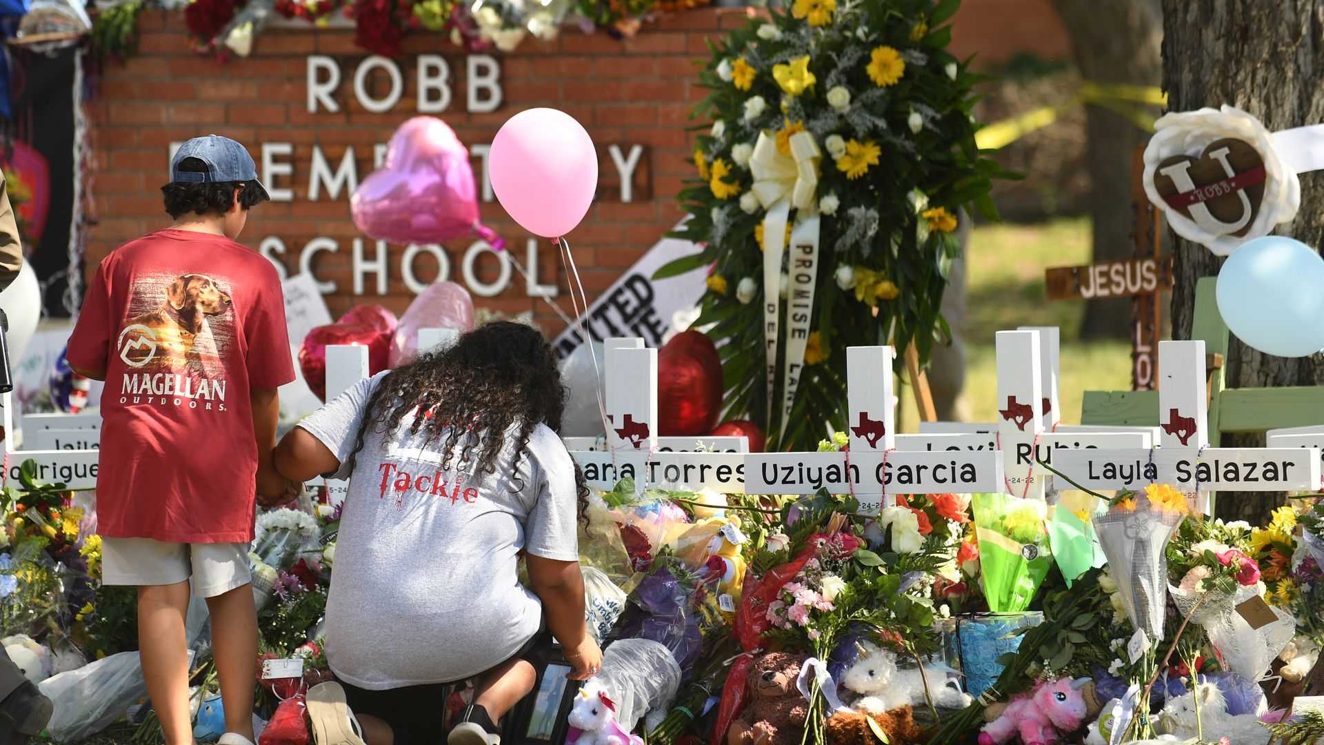 People place items outside of Robb Elementary School in Texas