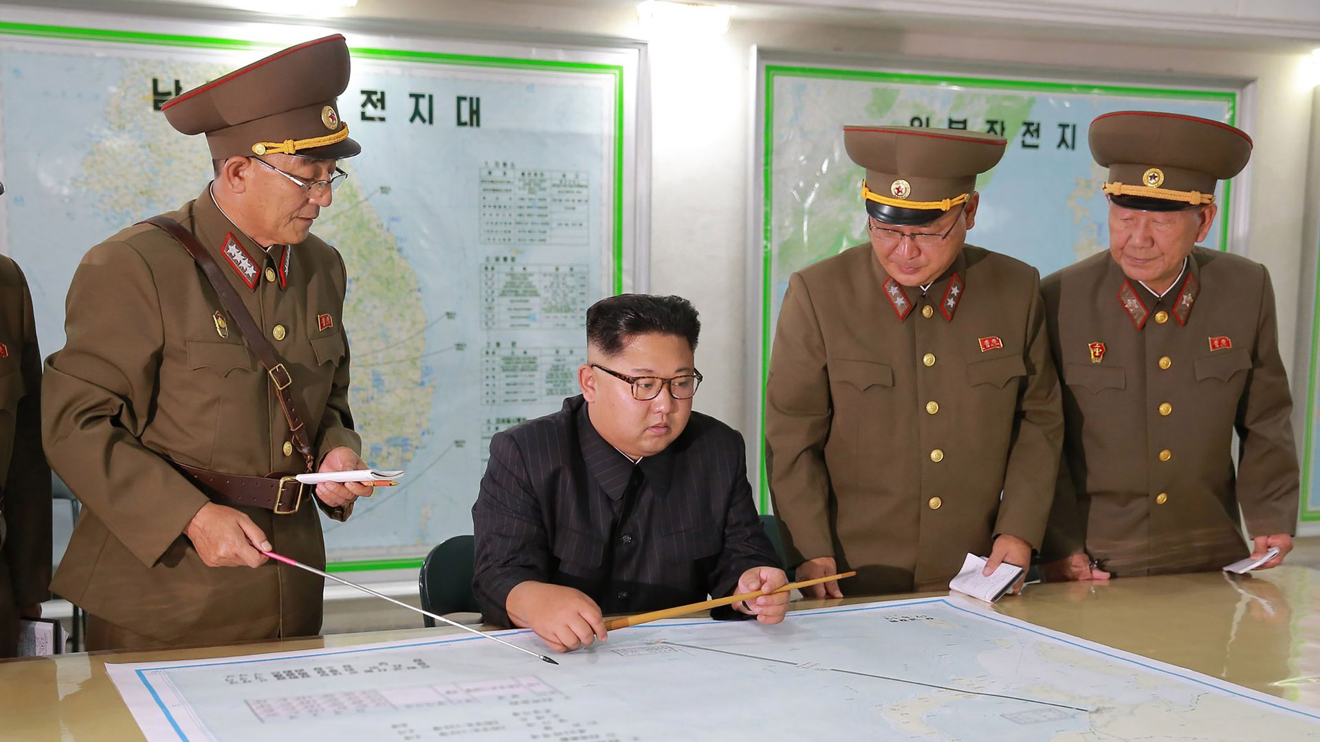 Kim Jong-un sits at a desk.