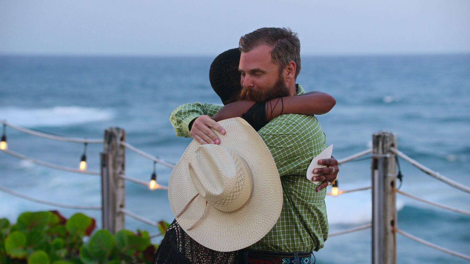 A man embraces a woman holding a cowboy hat