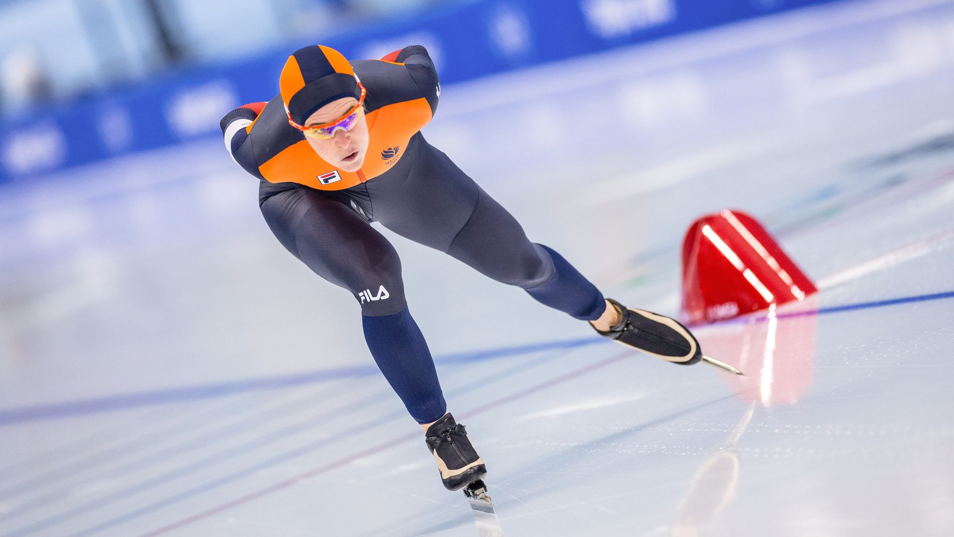 Photo of Ireen Wüst in uniform speed skating on ice during a competition