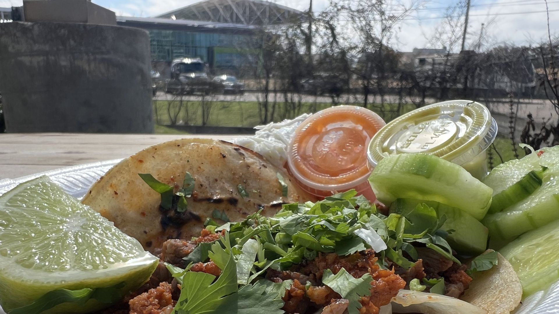 A taco in the foreground with Q2 stadium in the background.
