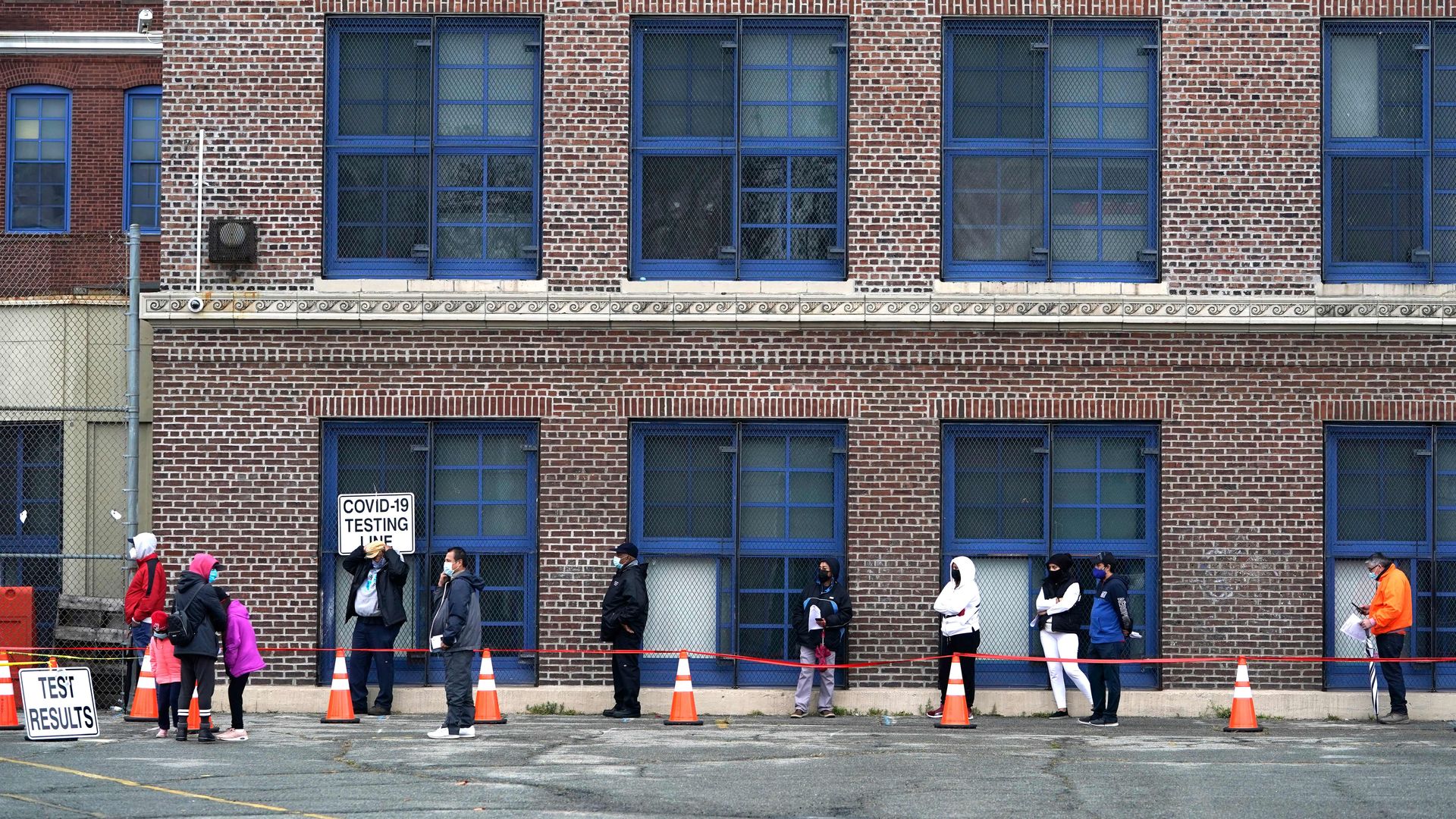Photo of people lining up outside a building to get tested for COVID-19