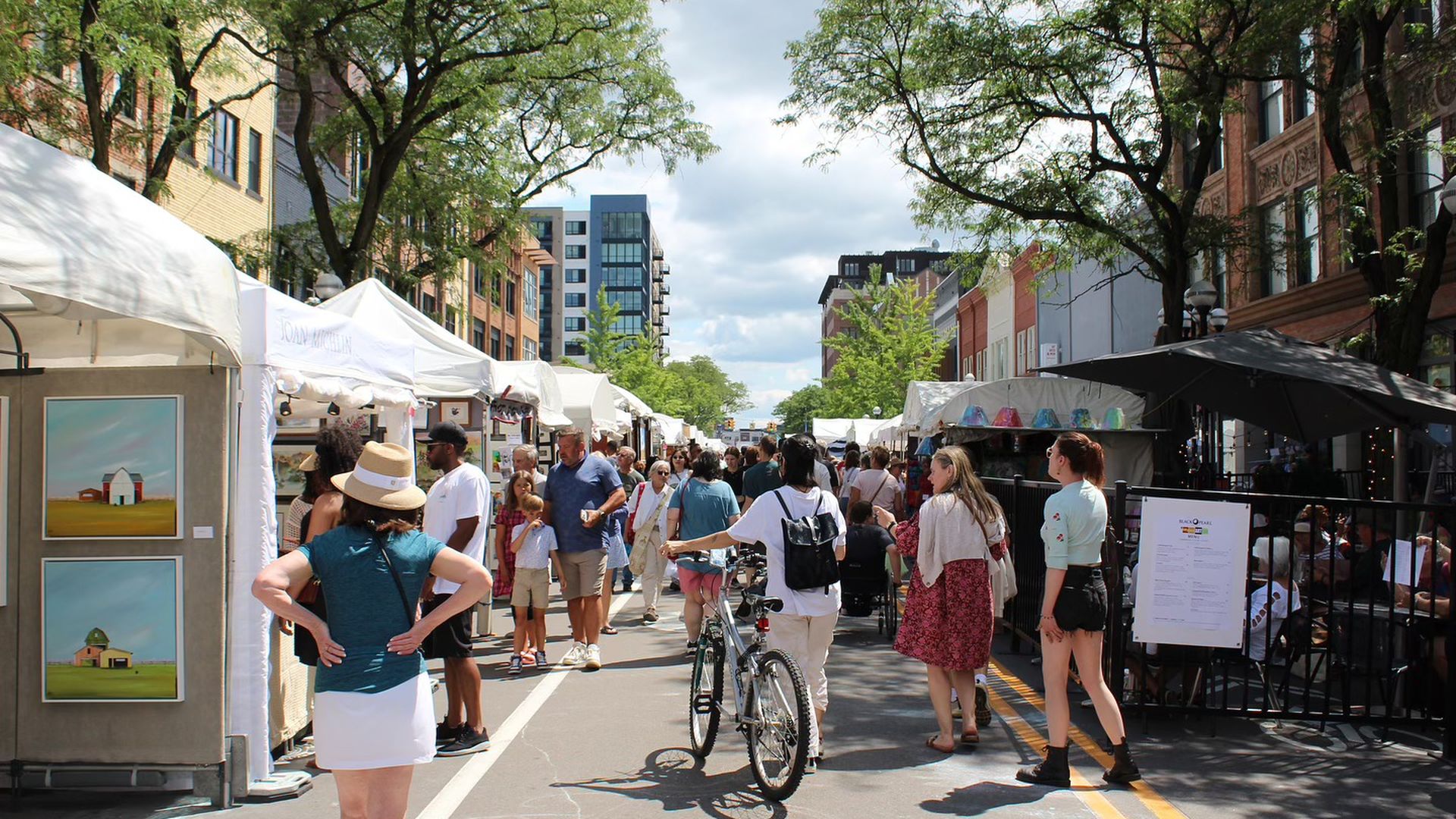 White tents line the street with art and visitors