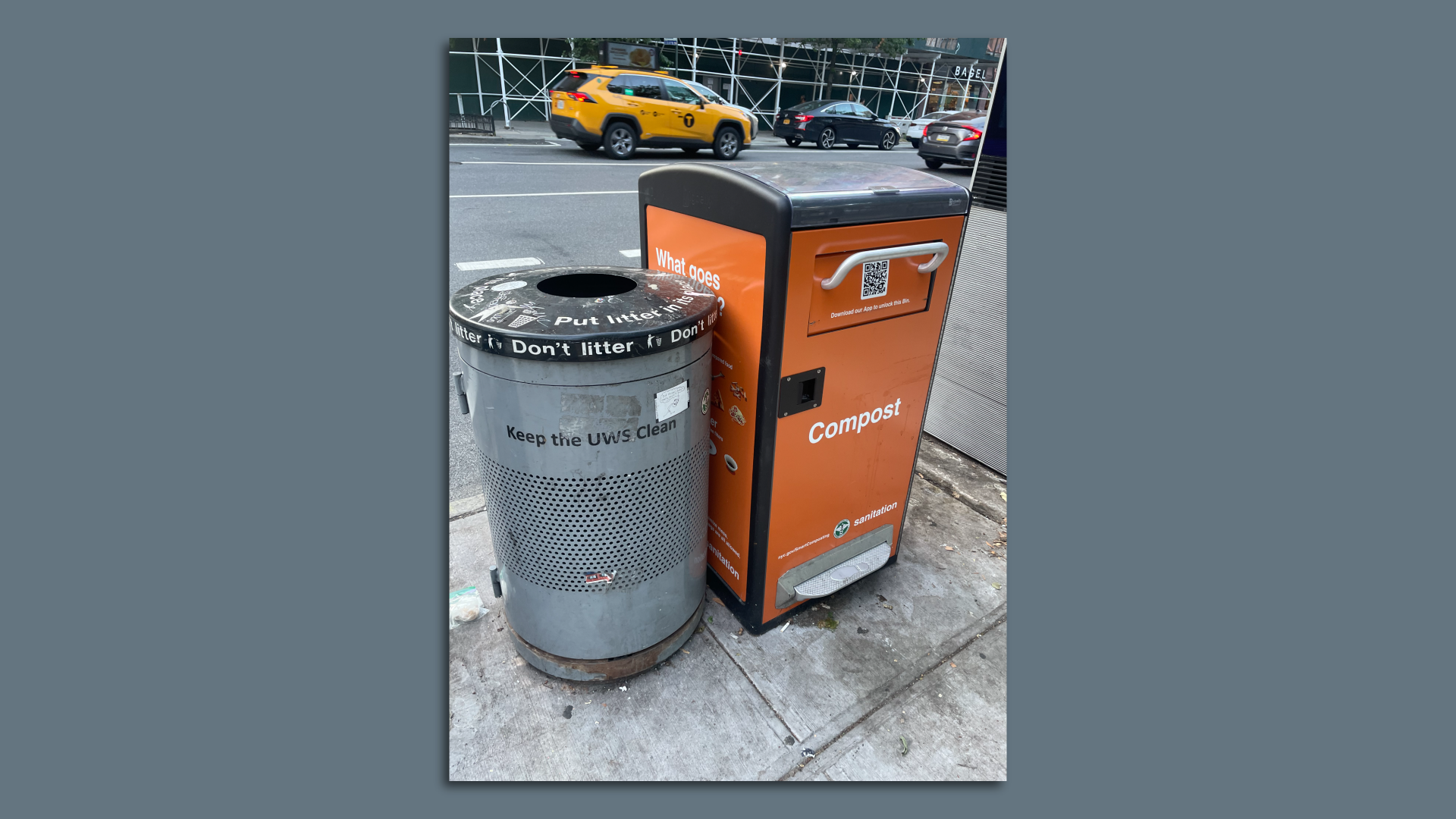A compost bin on a New York City street stands next to a recycling bin.