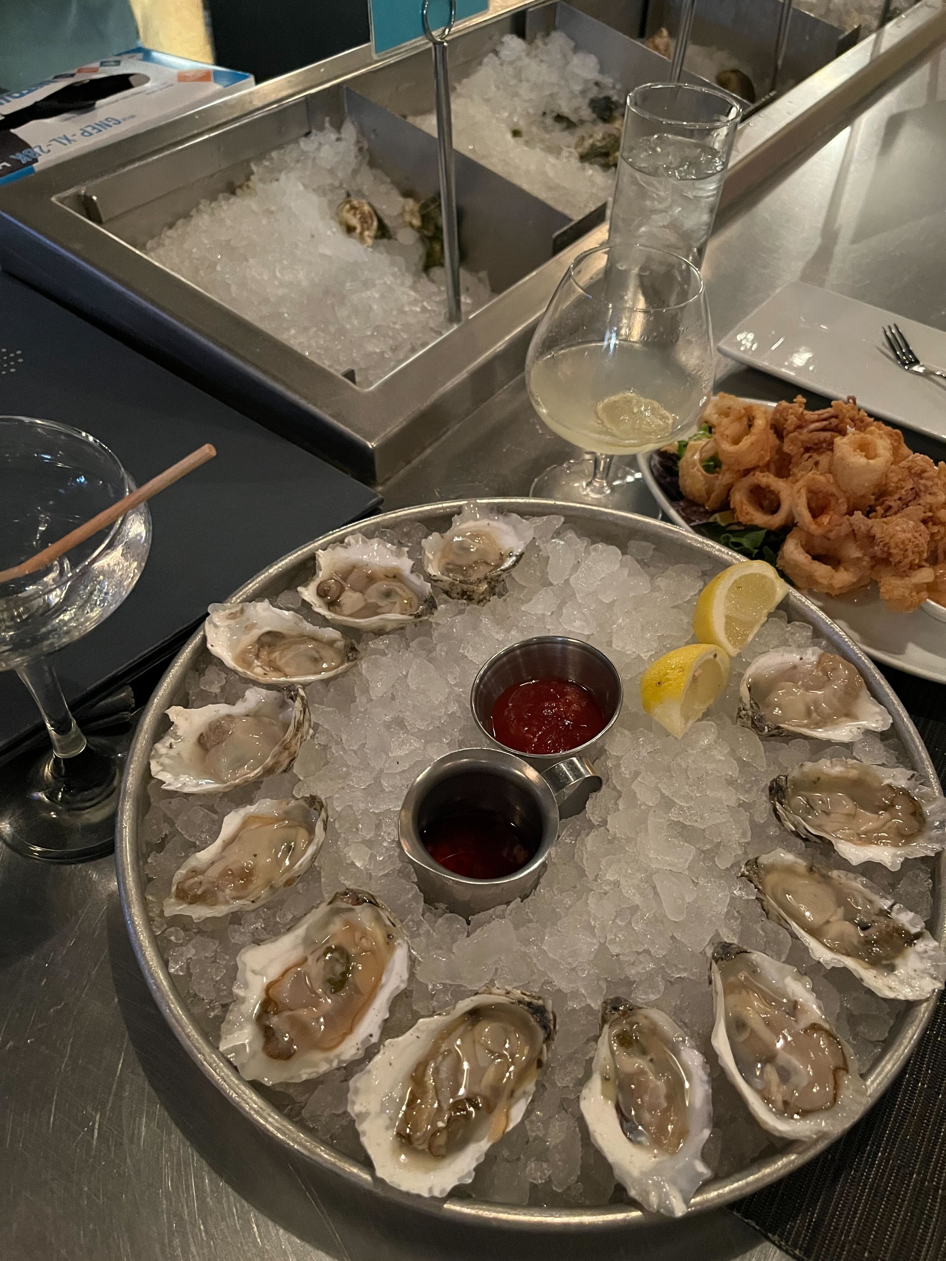 A tray of dozen oysters and fried calamari to the side