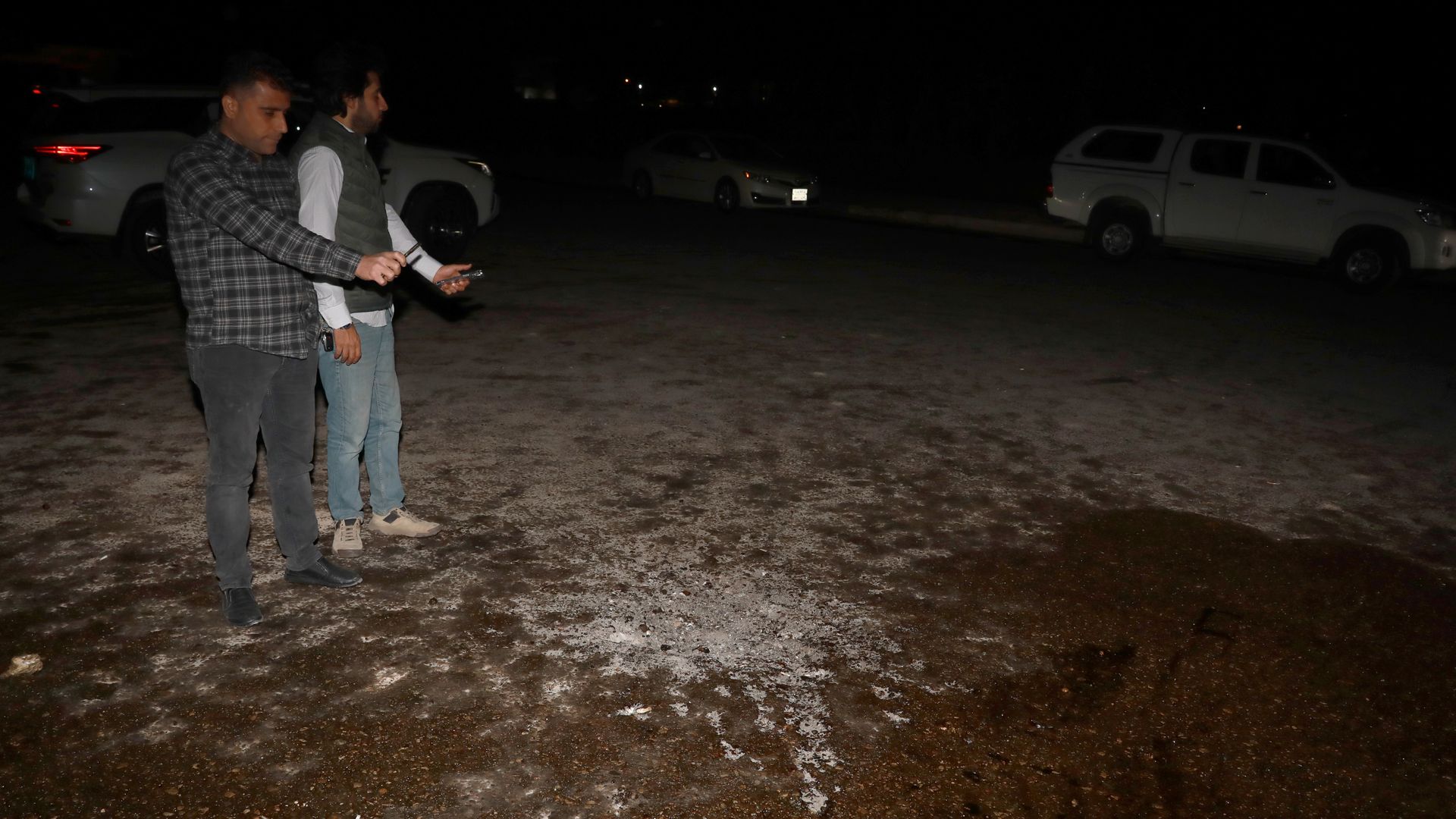 People inspect the area where one of the fired rockets was hit at Bahtiyari neighborhood on February 15