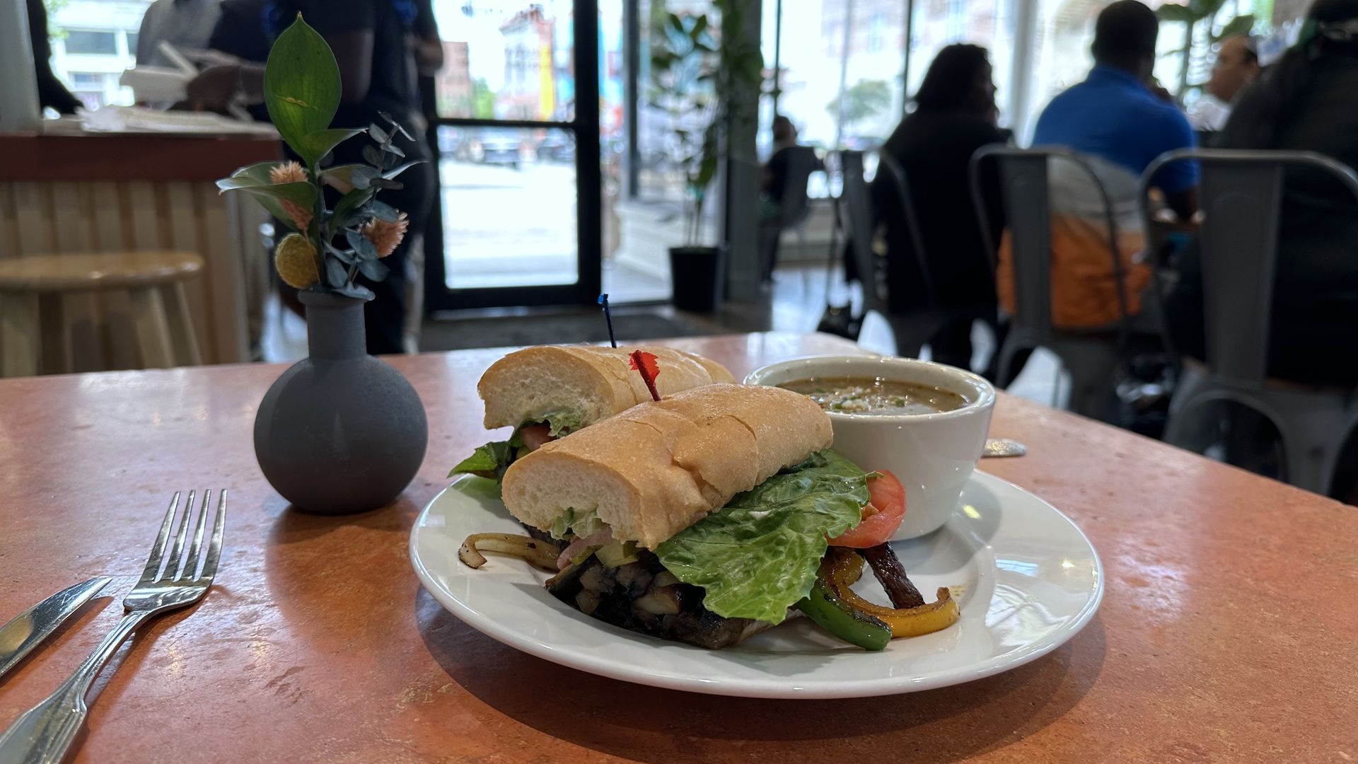 Photo shows a mushroom and pepper poboy on a plate.