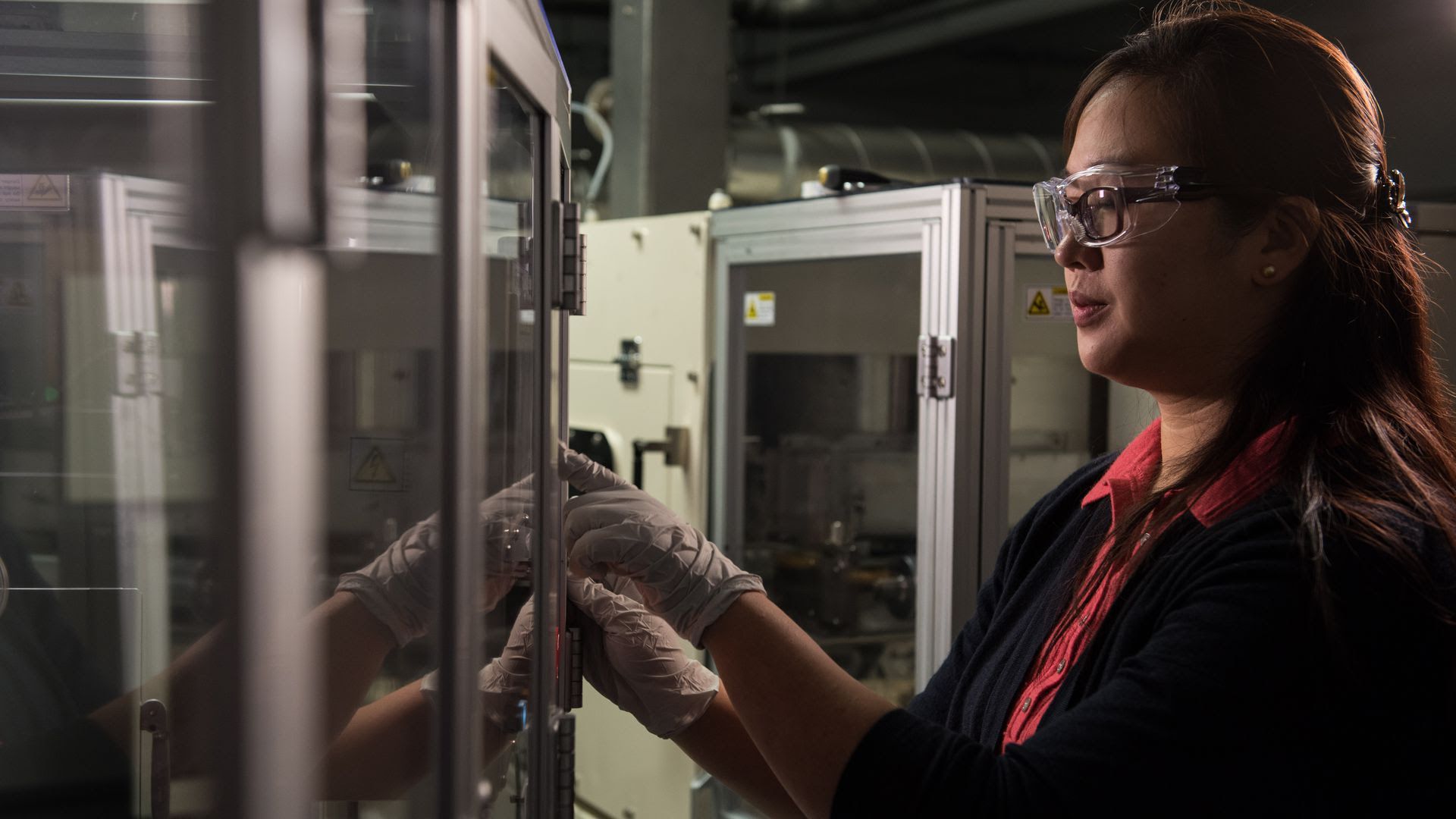 A woman presses buttons in a lab.