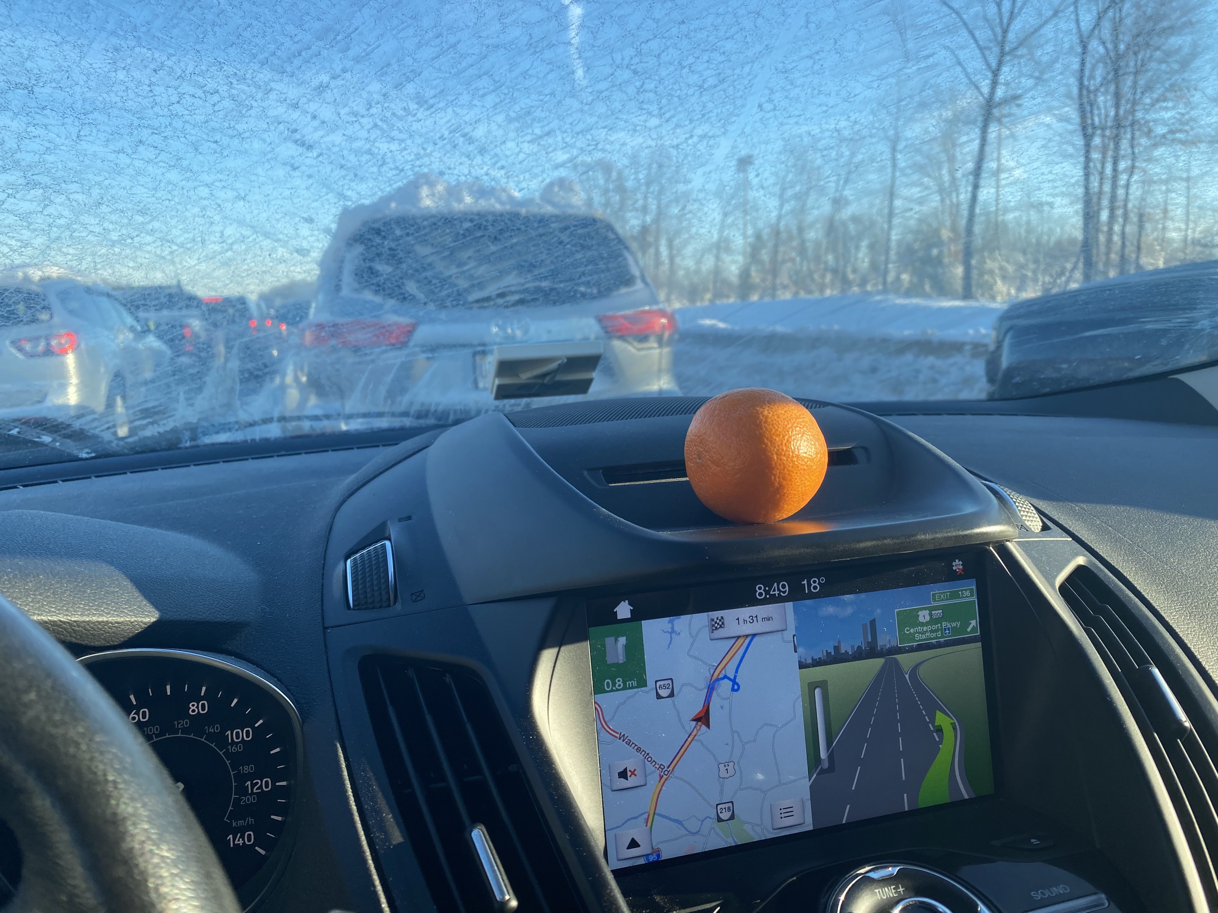 An orange on a car dashboard 