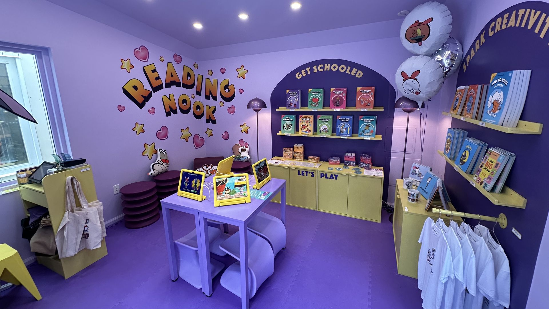 The inside of Mrs. Wordsmith's pop-up in the Seaport, which includes workbooks, iPads with video games and card games related to phonics and vocabulary.