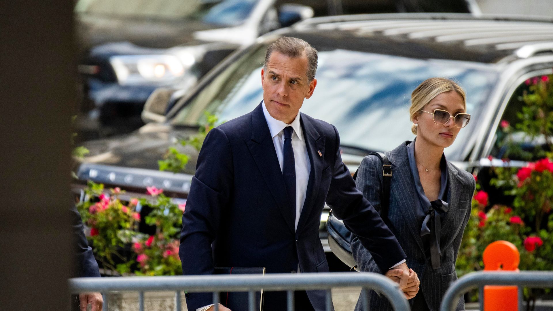Hunter Biden heads into a courthouse with his wife, Melissa.