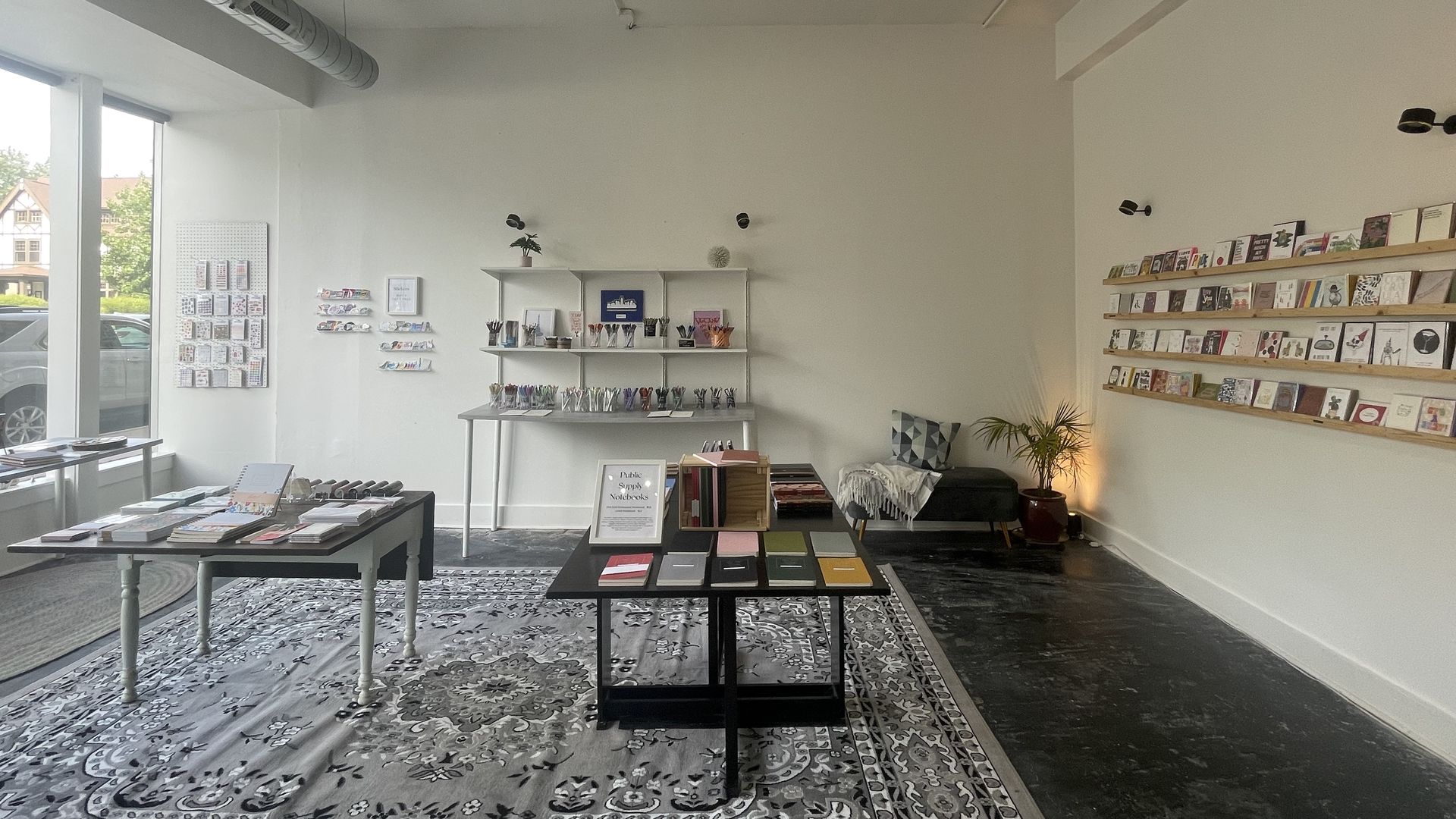 A shop with cards on the walls and tables in the middle