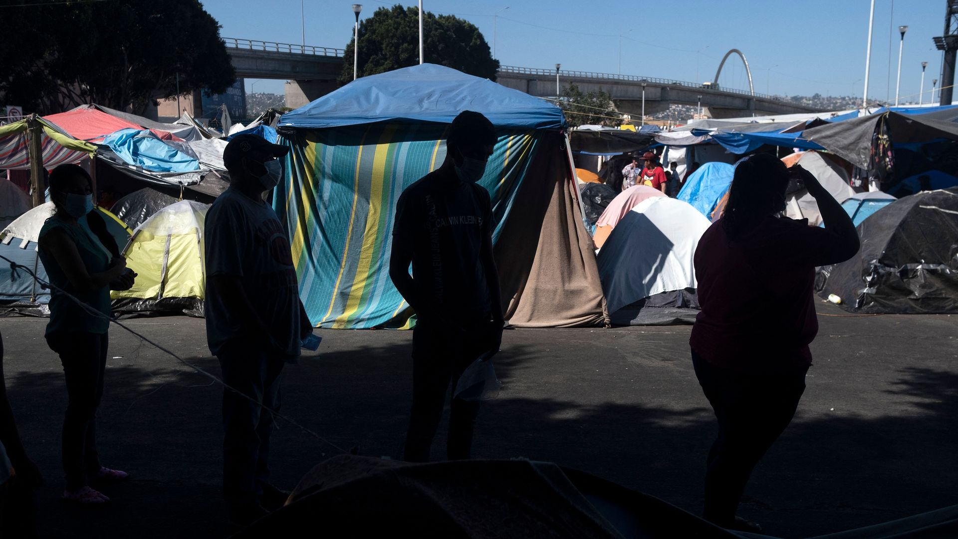 Photo of migrants lined up at a border camp