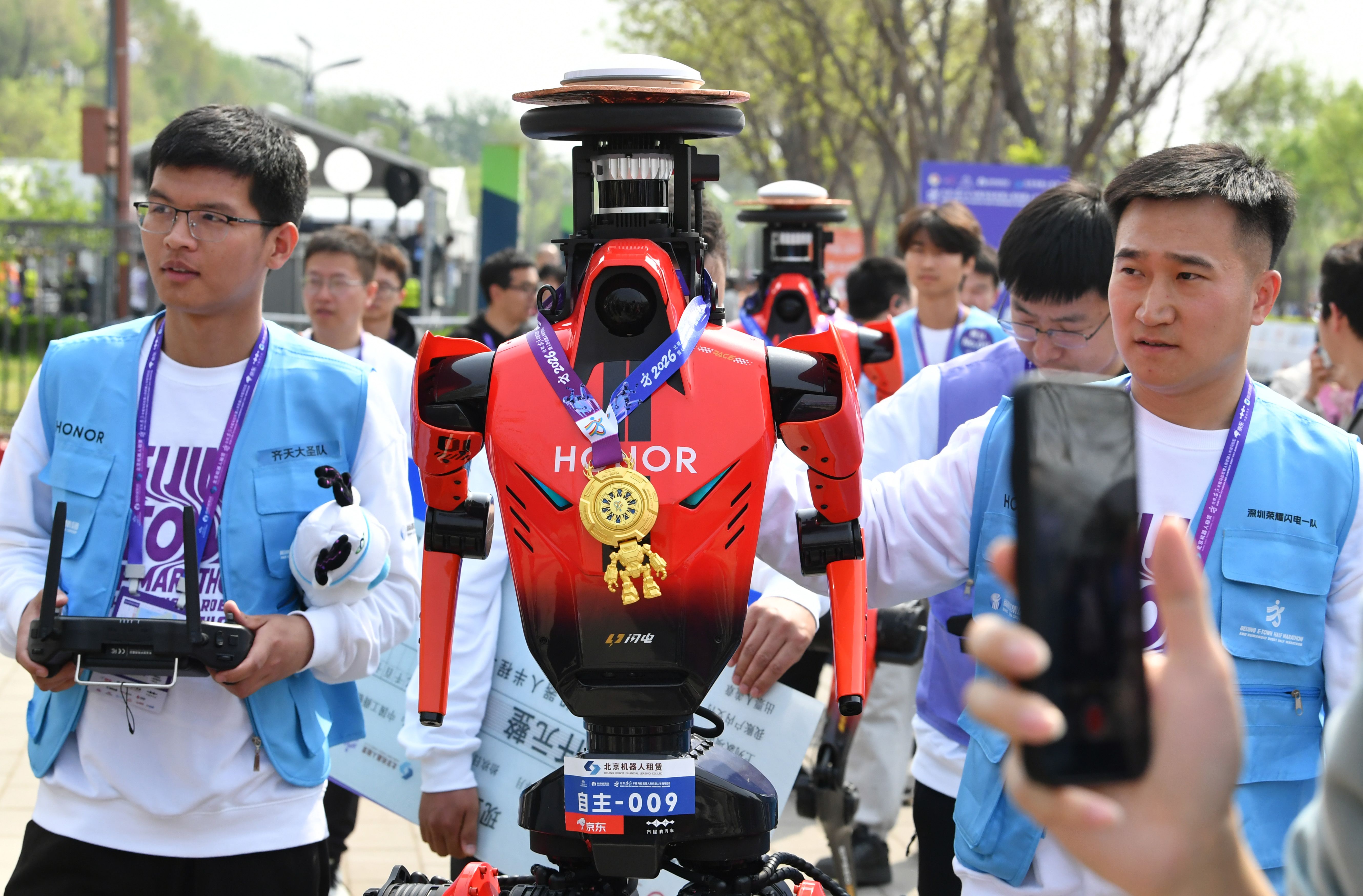 Smartphone maker Honor's humanoid robot wears a medal after finishing the race. 