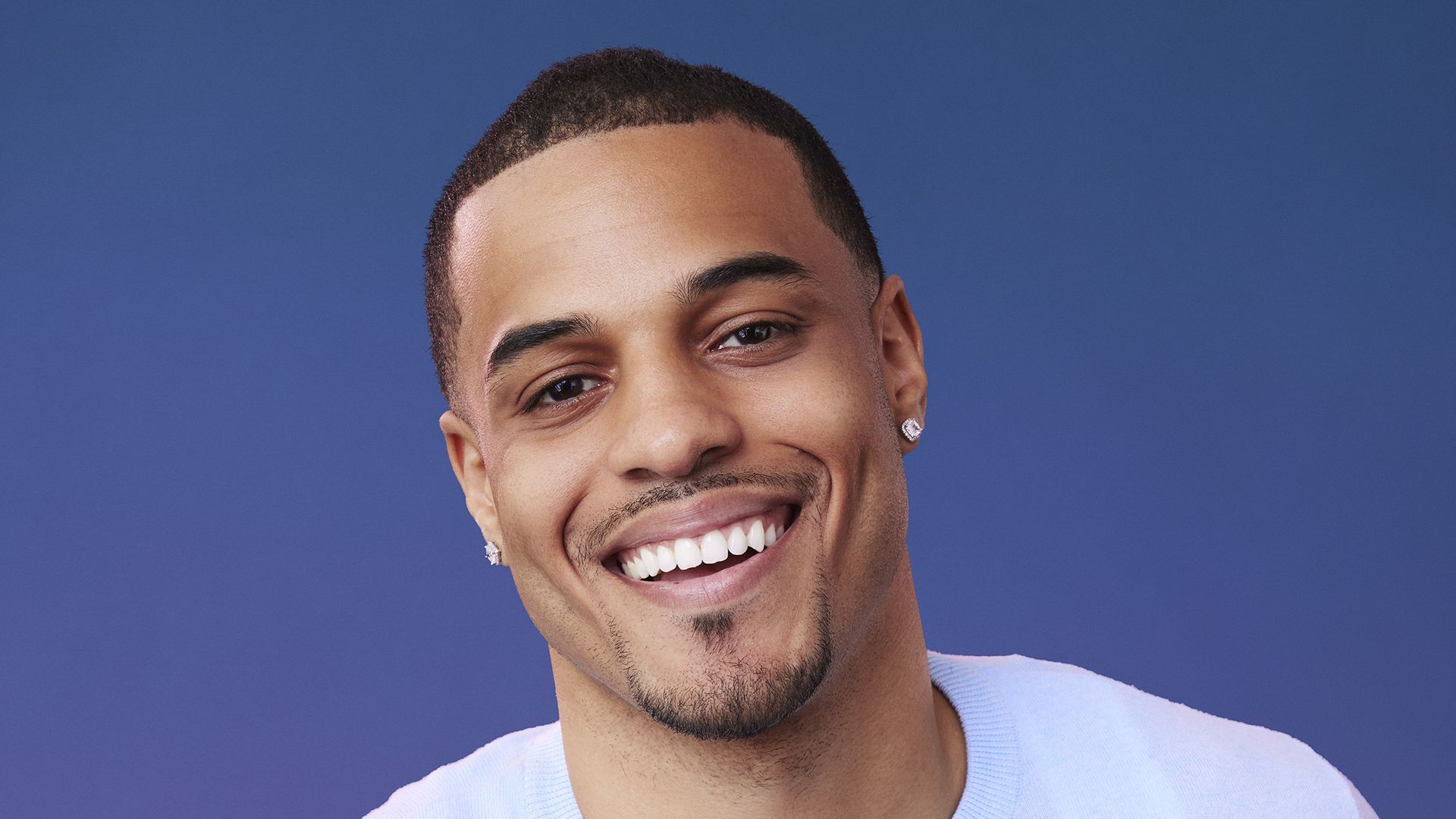 Photo of a man in a blue backdrop. 