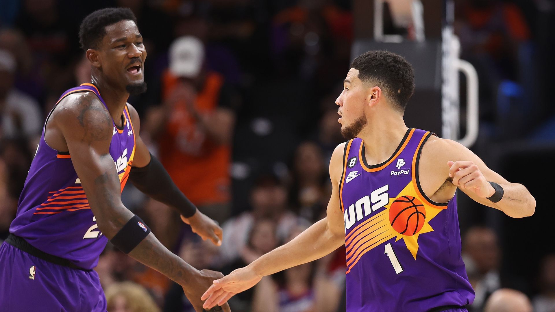 Deandre Ayton and Devin Book slap hands in celebration during a Phoenix Suns game