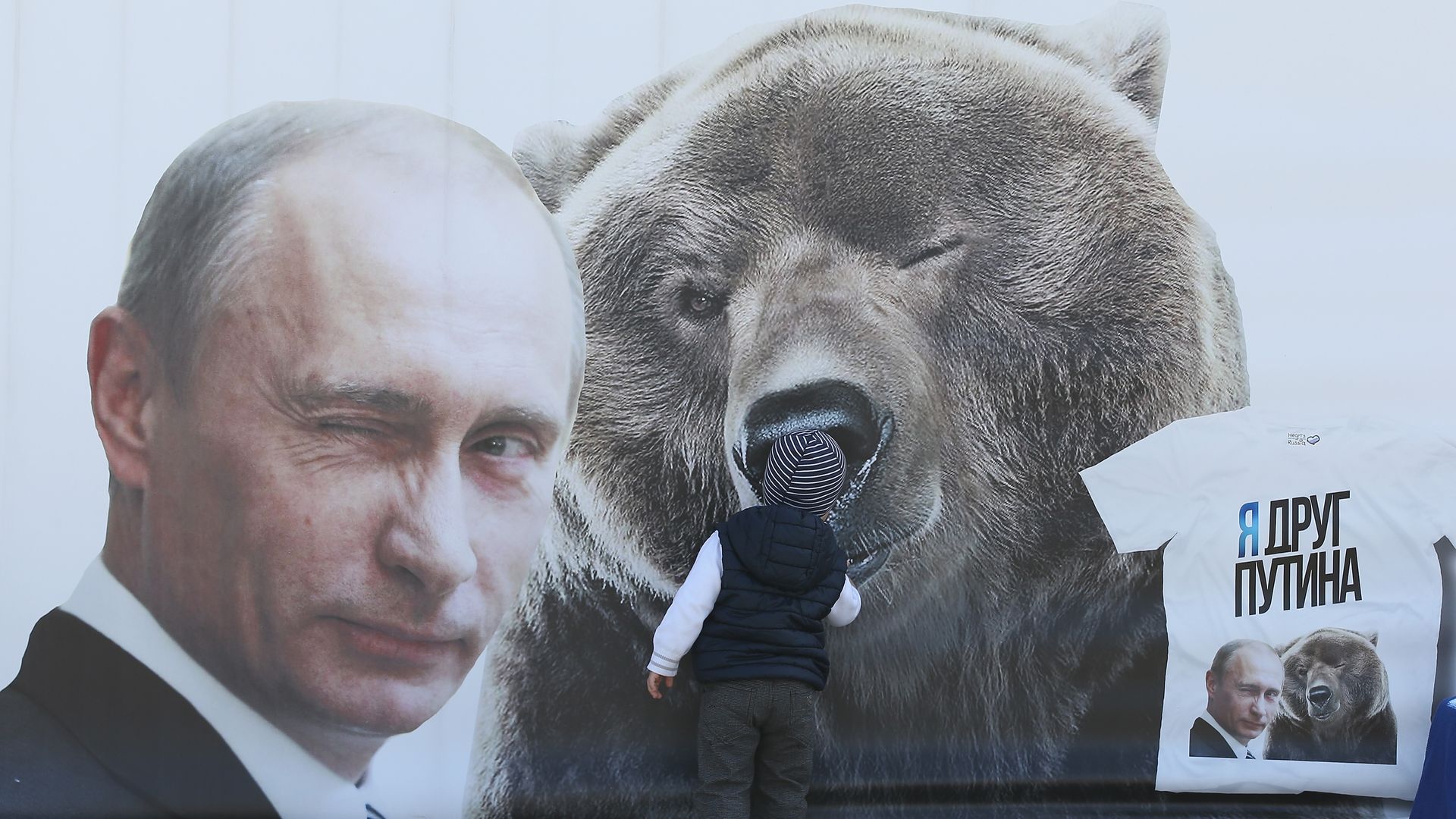 Billboard of winking Vladimir Putin next to a winking bear. They are winking different eyes. 