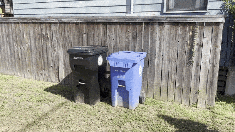 Image shows a woman dumping recycling items into a blue recycling cart.