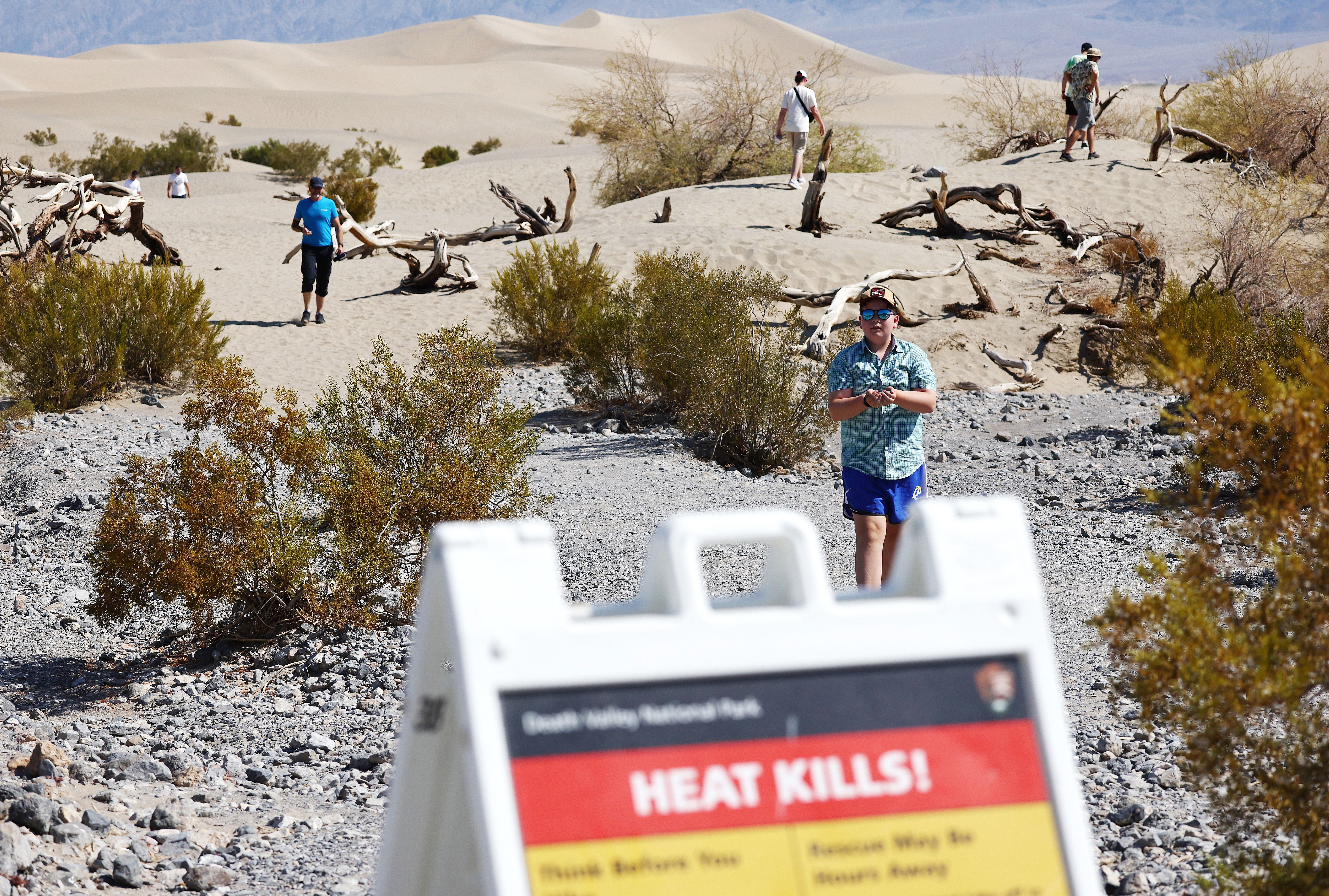 Visitors walk in the morning, when temperatures are less hot, at Mesquite Flat Sand Dunes during a long-duration heat wave which is impacting much of California on July 9, 2024 in Death Valley National Park, California. 
