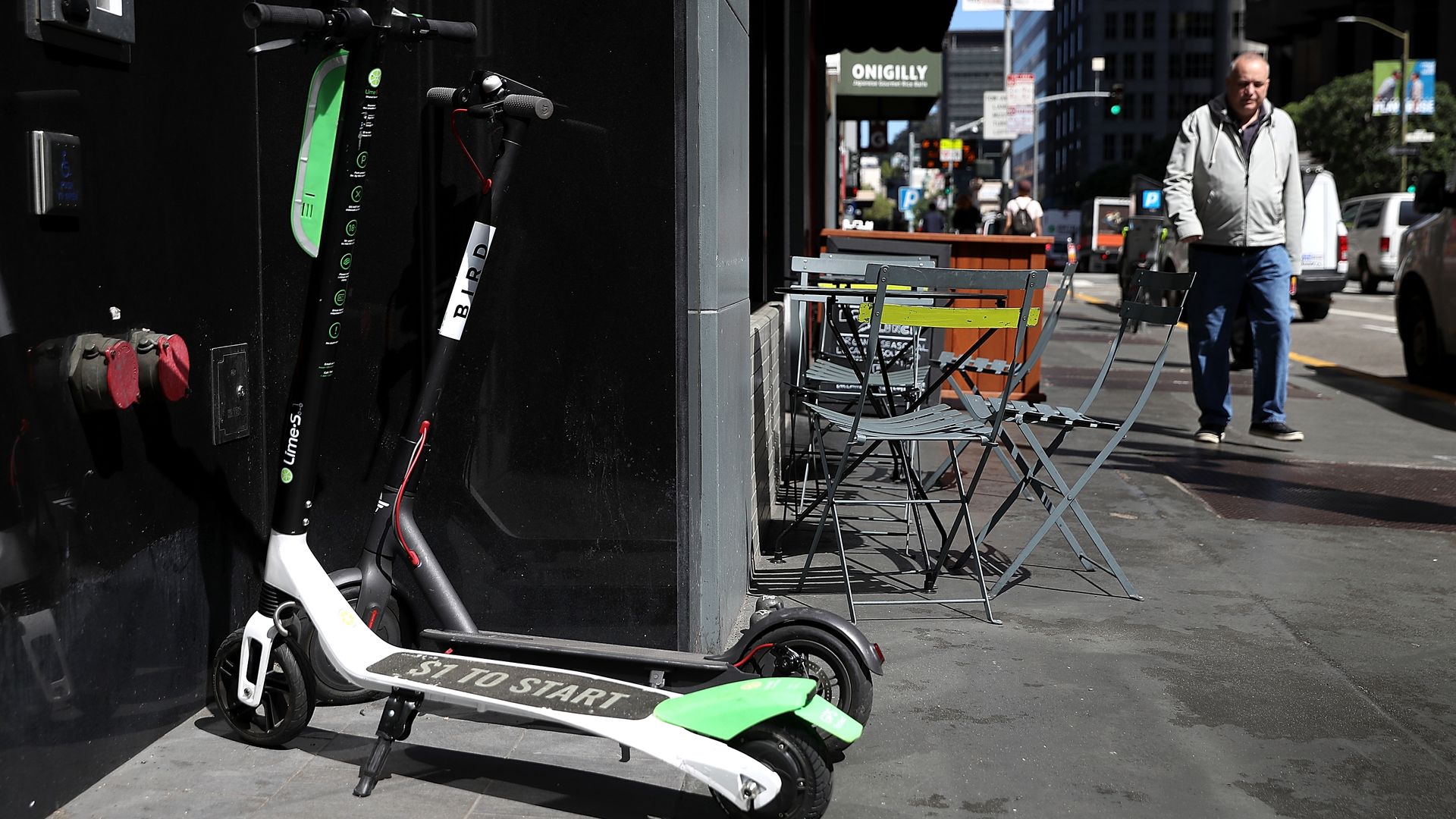 A Bird and Lime scooter on the sidewalk. 