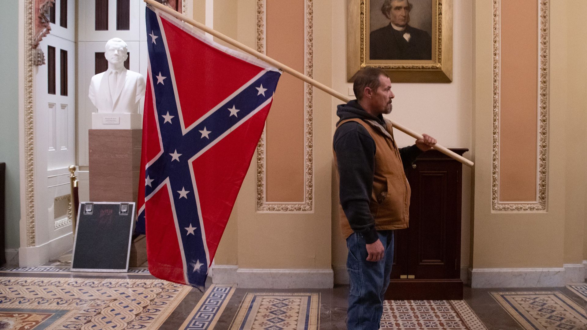 A supporter of US President Donald Trump holds a Confederate flag