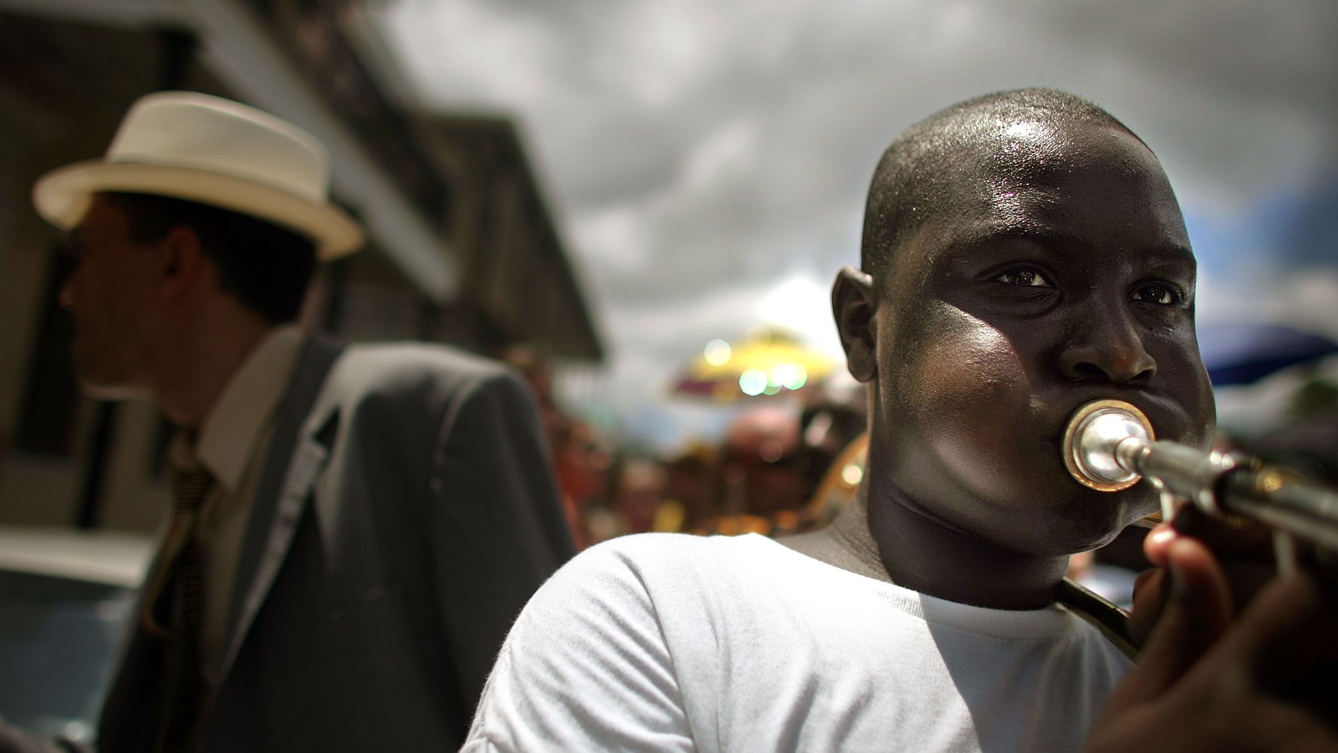 Photo shows a man playing a musical instrument.