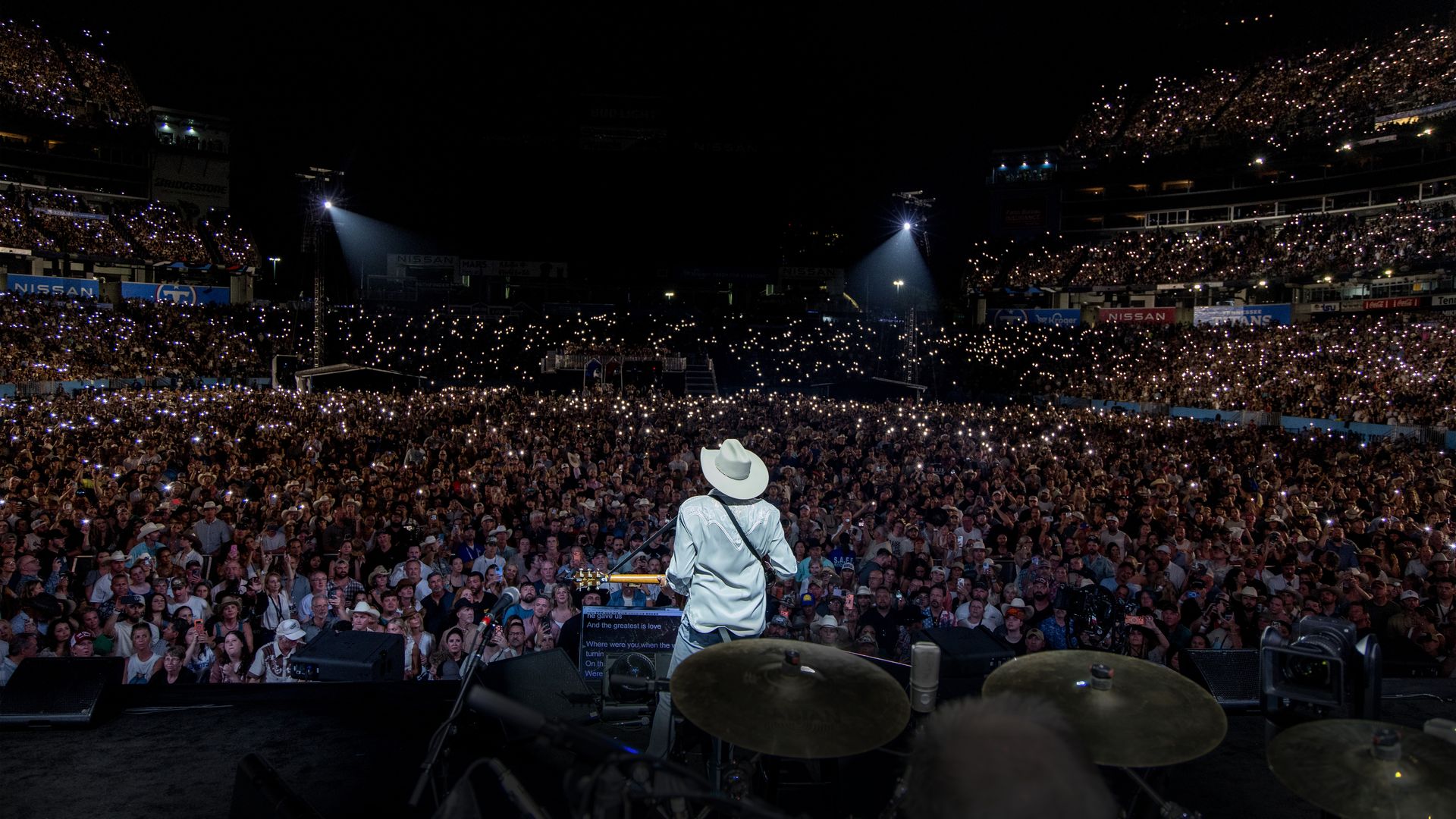 Alan Jackson on stage facing the crowd at Nissan Stadium.