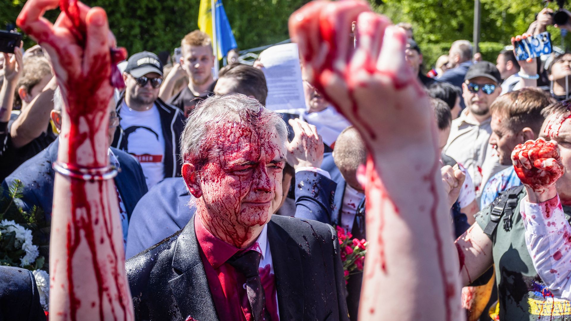 Russian Ambassador to Poland, Ambassador Sergey Andreev reacts after being covered with red paint during a protest.