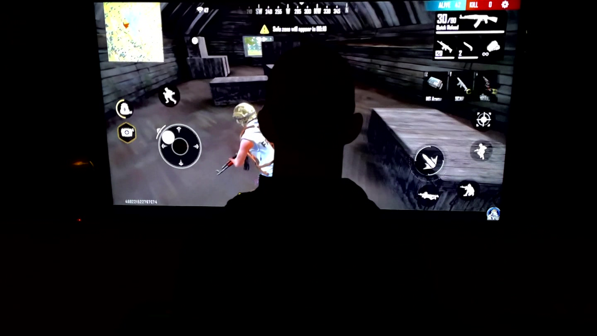 The back of a teenage boy's head is obscured as he plays a video game