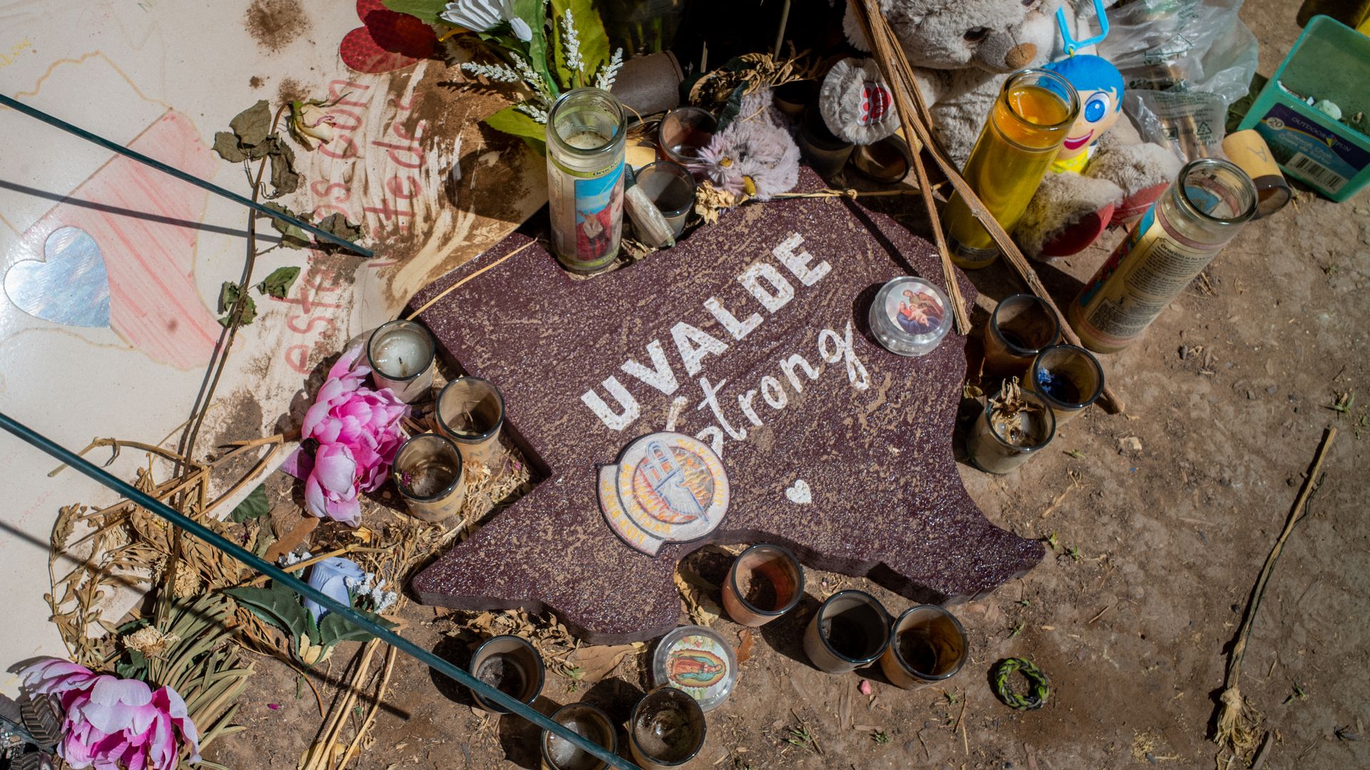 Photo of a sign in the shape of Texas that says "Uvalde strong," surrounded by flowers