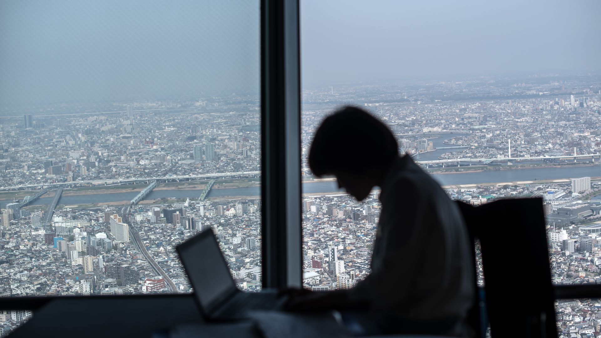 Employee in sihlouette uses a laptop