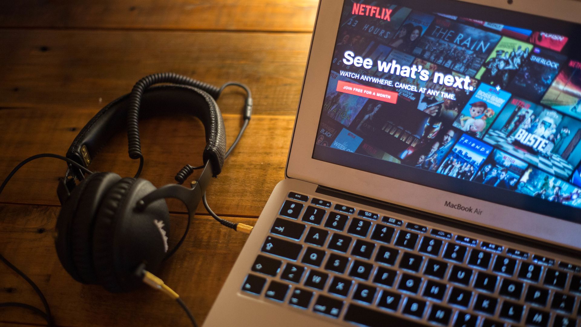 A pair of headphones next to a laptop, with the Netflix homepage pulled up.