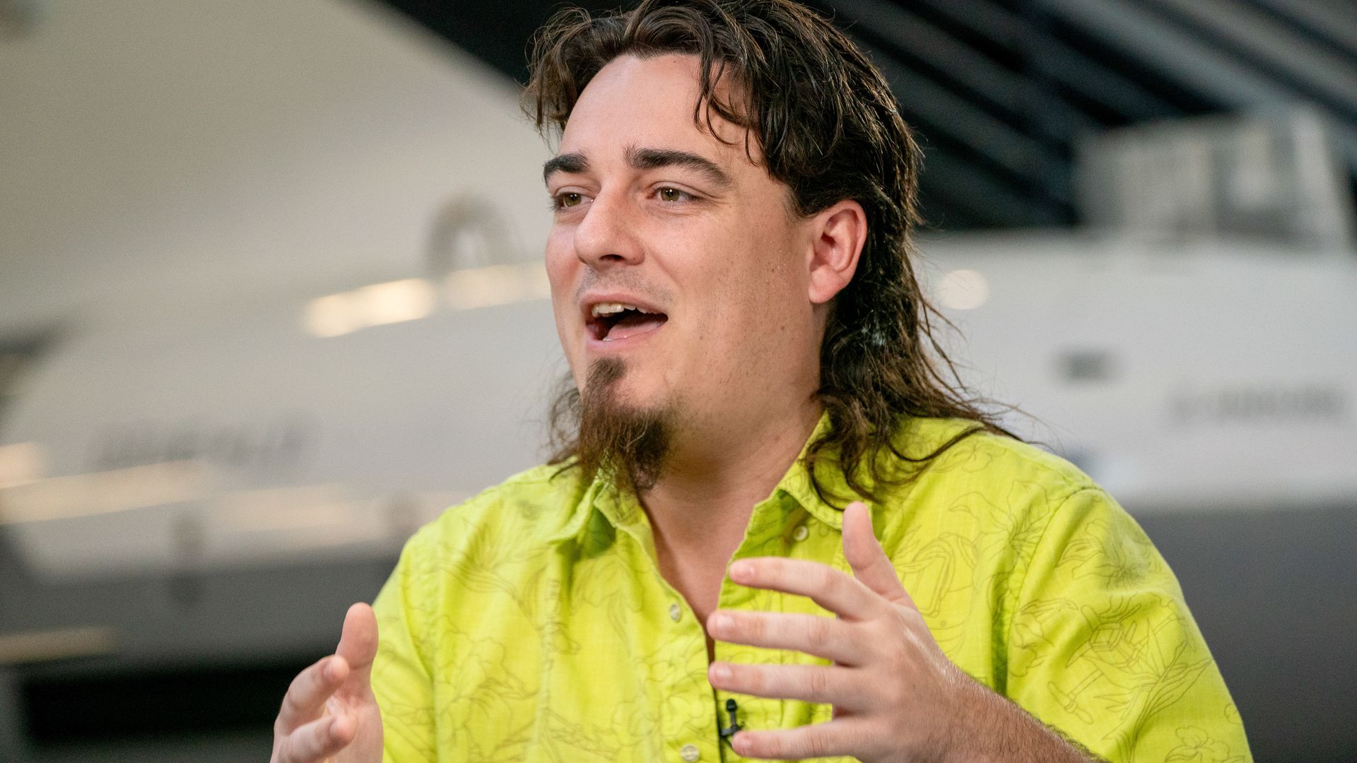 Palmer Luckey, looking to his right, gesturing with his hands.