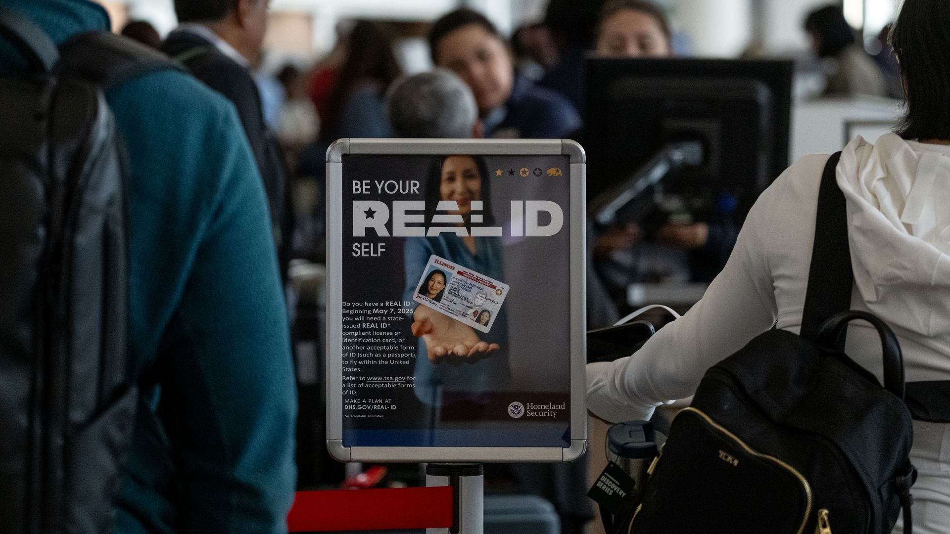 A flyer advertising and explaining what a REAL ID is at an airport security line.