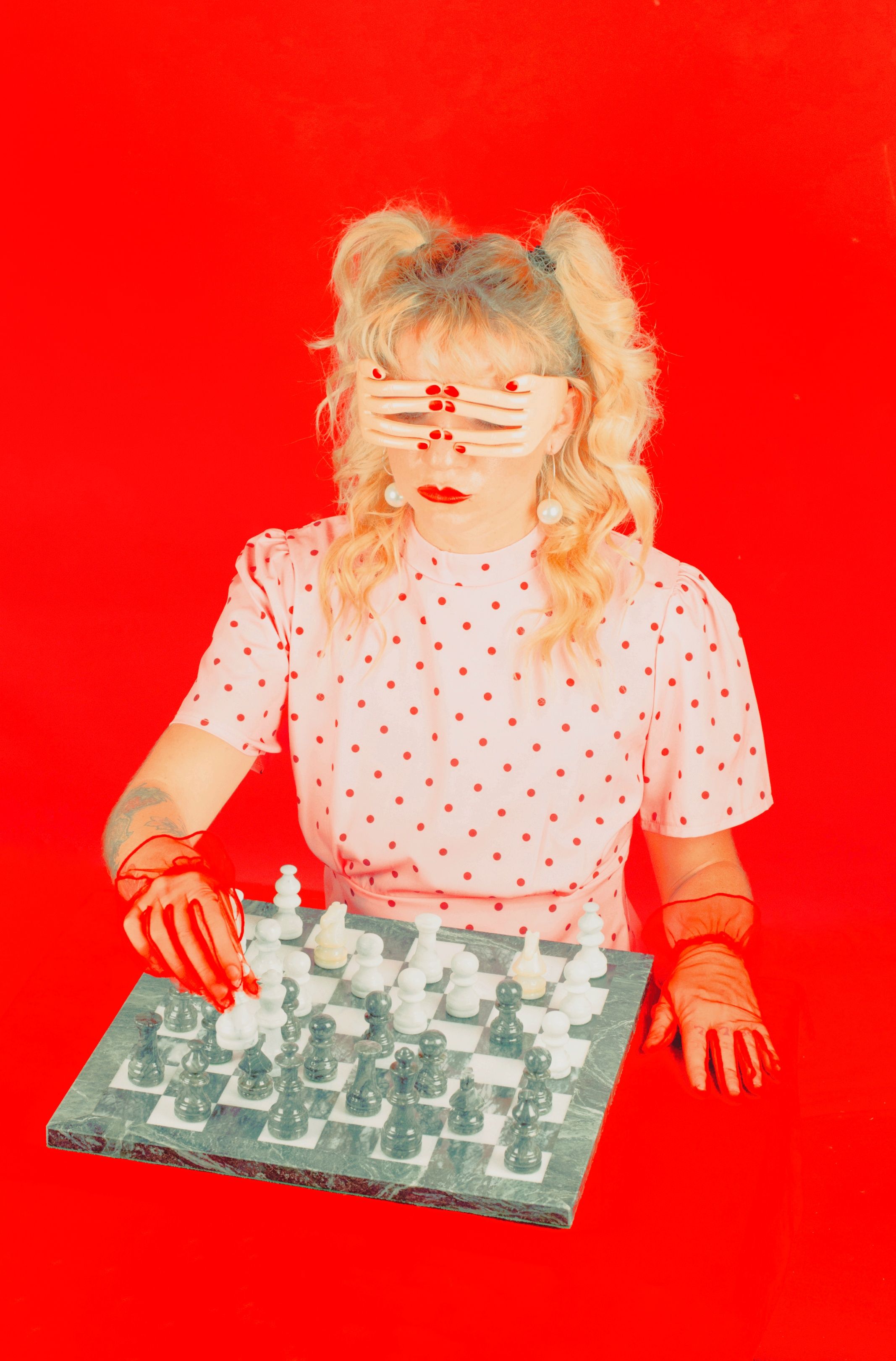 Woman with hands over her eyes playing chess