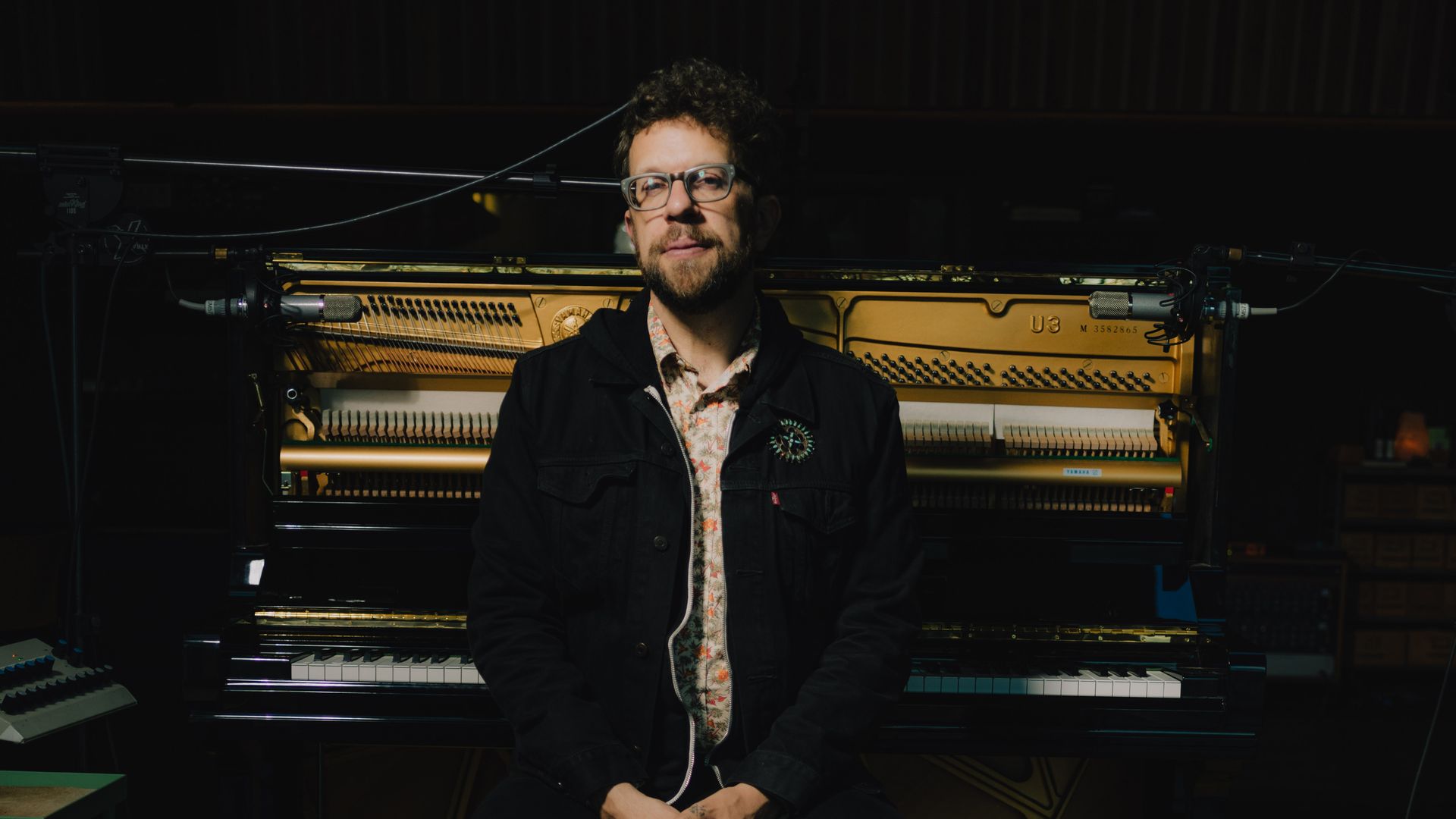 Phil Cook stands in front of a piano