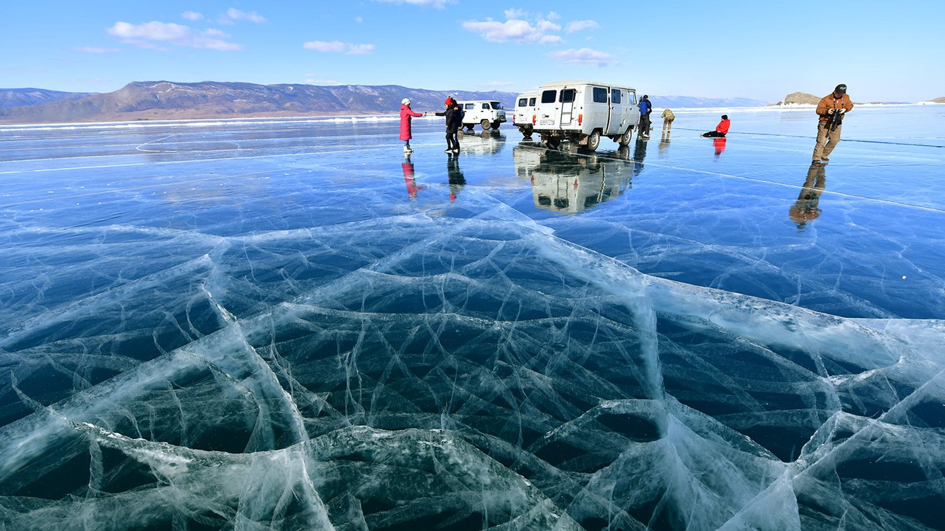 Photo of people and a van on top of a frozen lake