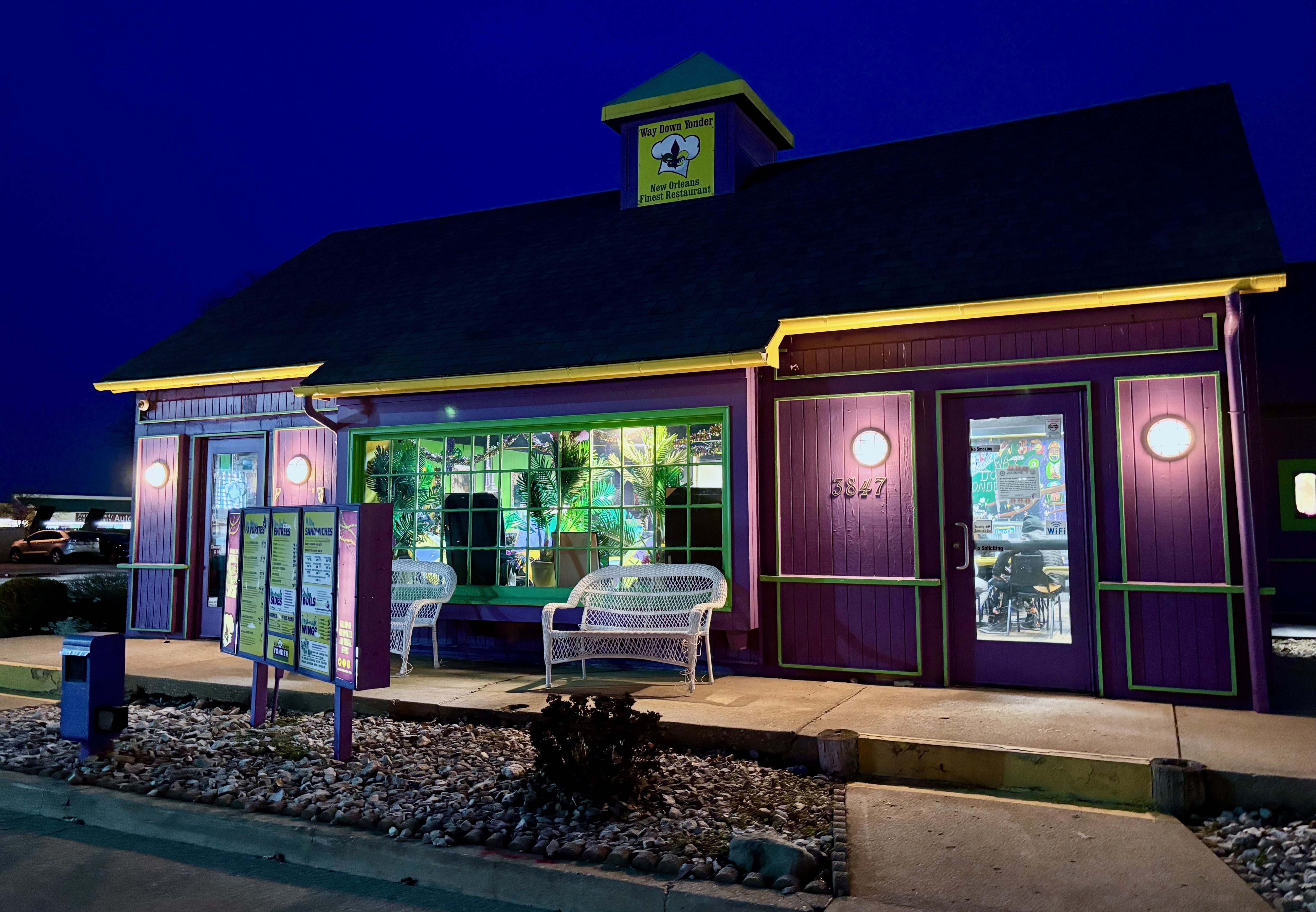 The exterior of Way Down Yonder at night, painted in purple and yellow