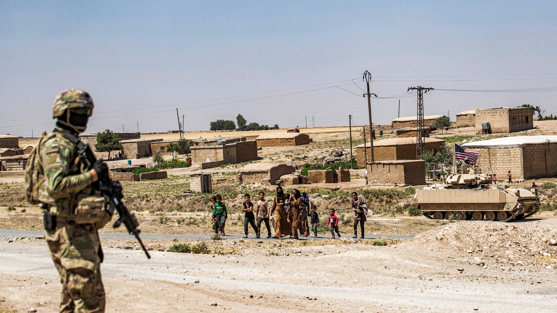 A US soldier looks on as locals approach during a US military patrol in Rumaylan (Rmeilan) in Syria's northeastern Hasakeh province on June 22, 2021