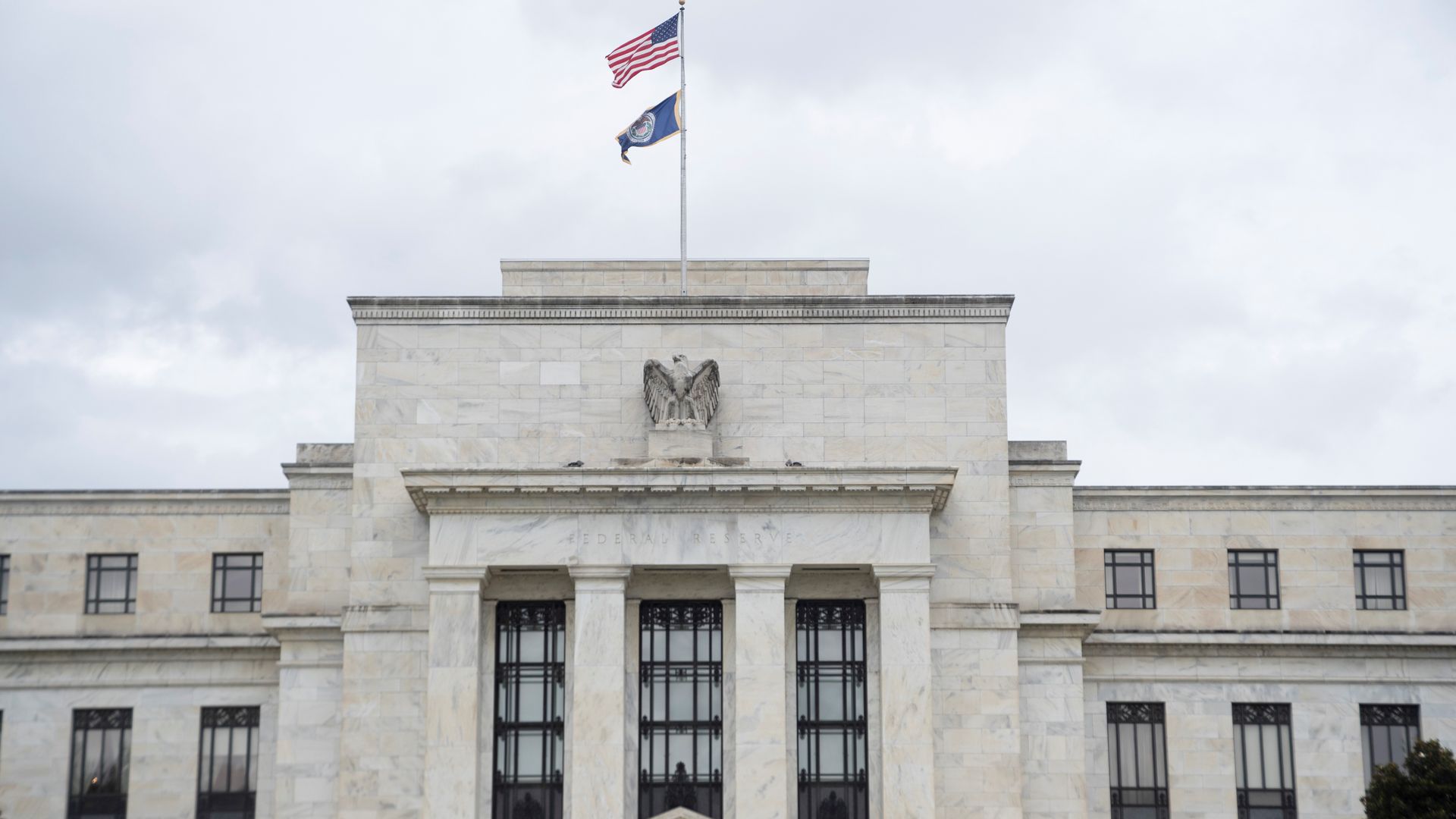 Photo of the U.S. Federal Reserve building with two flags at the top